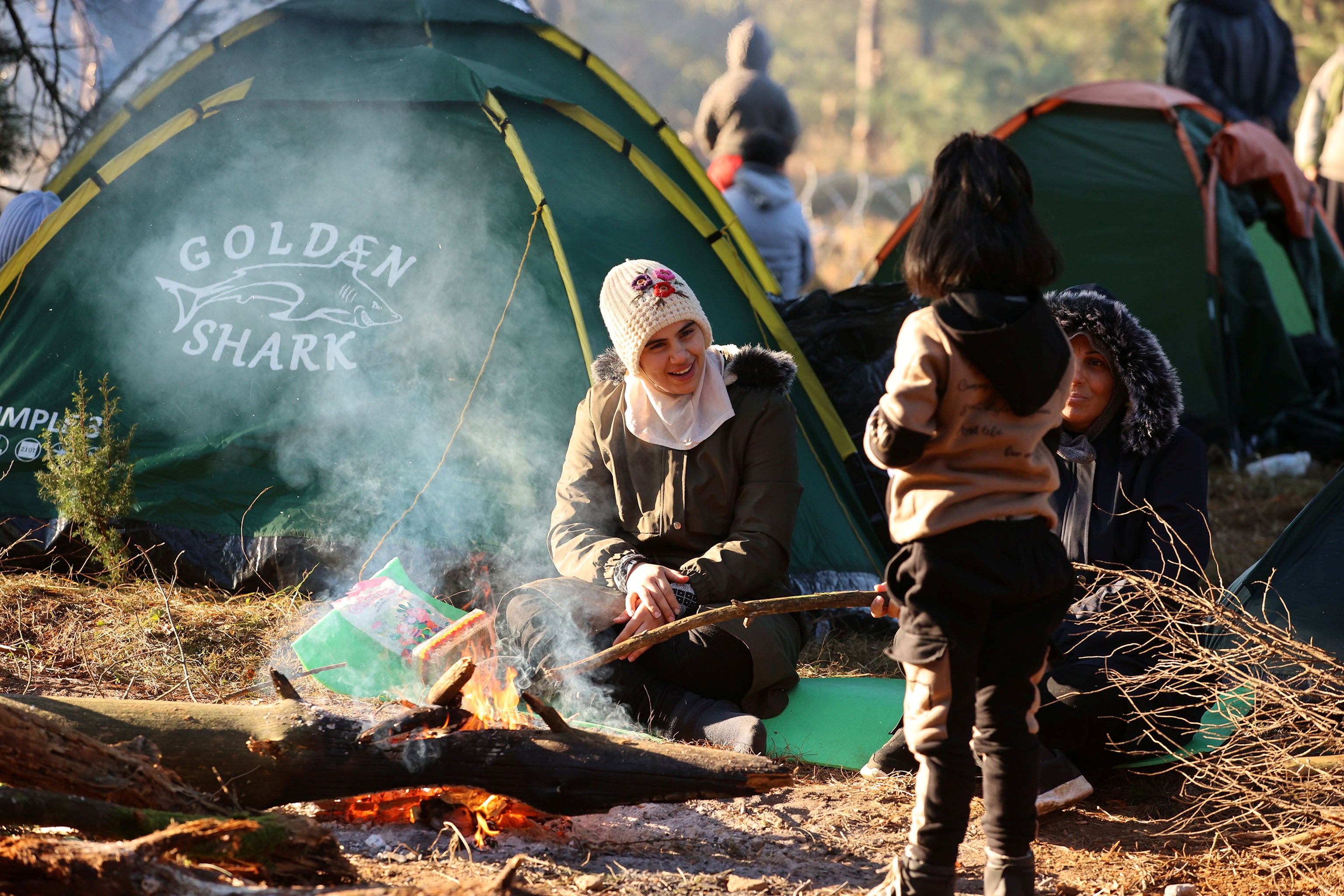 Migrants gather near a fire on the Belarusian-Polish border in the Grodno region