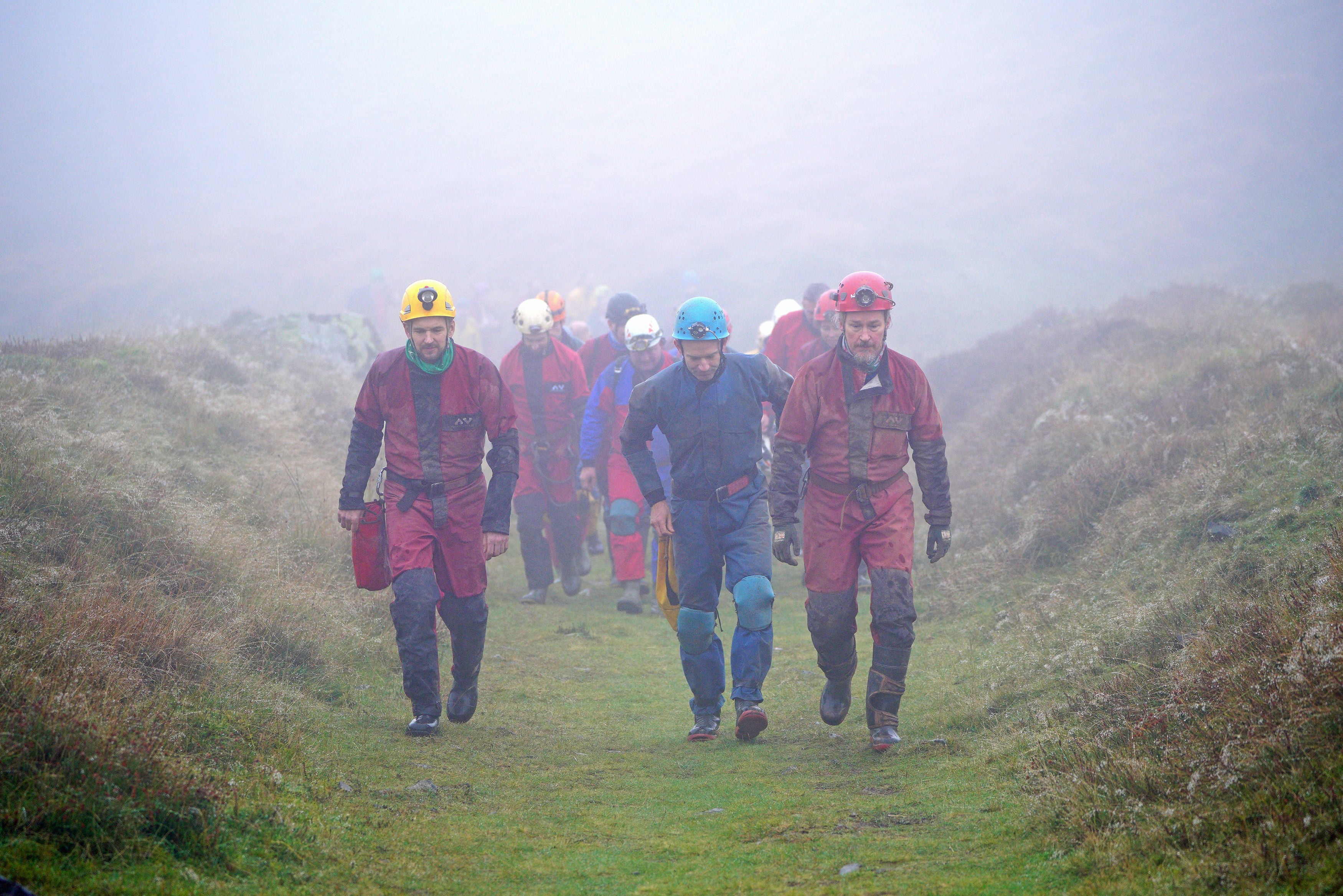 Rescuers walk towards the Ogof Ffynnon Ddu cave system near Penwyllt, Powys in the Brecon Beacons