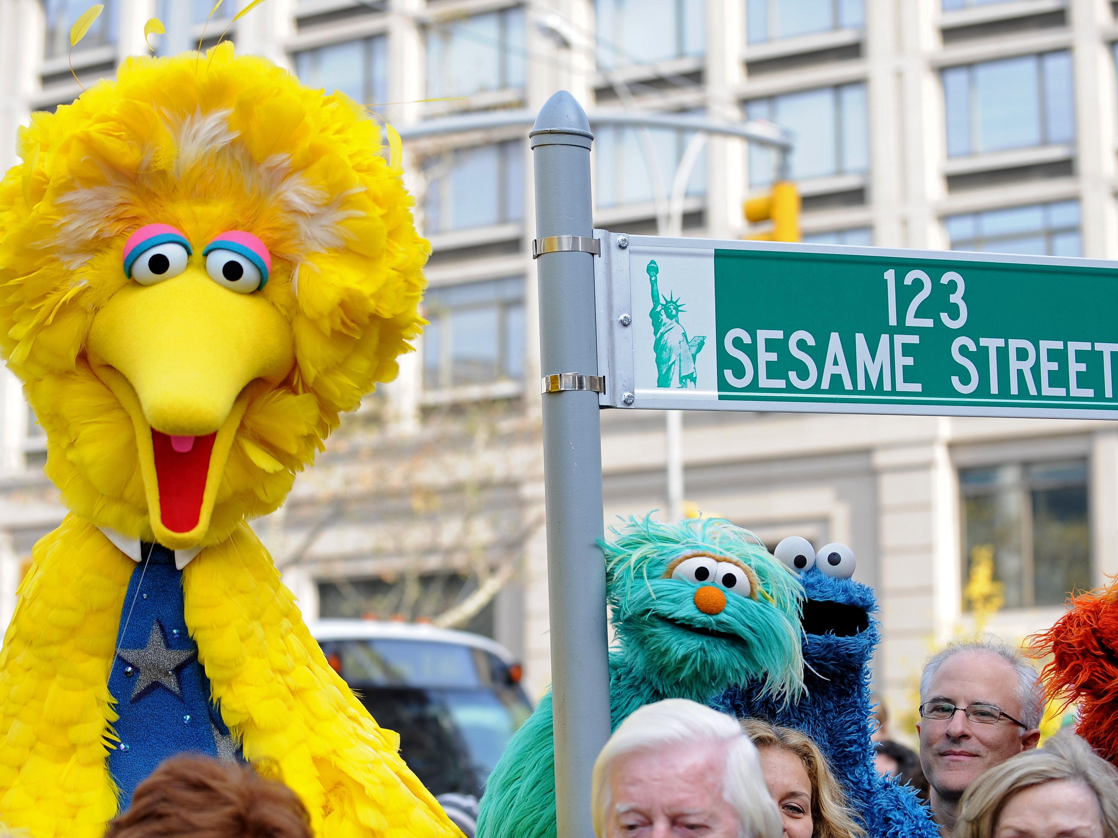 Big Bird and other Sesame Street puppet characters post net to a temporary street sign on 9 November 2009 in New York City