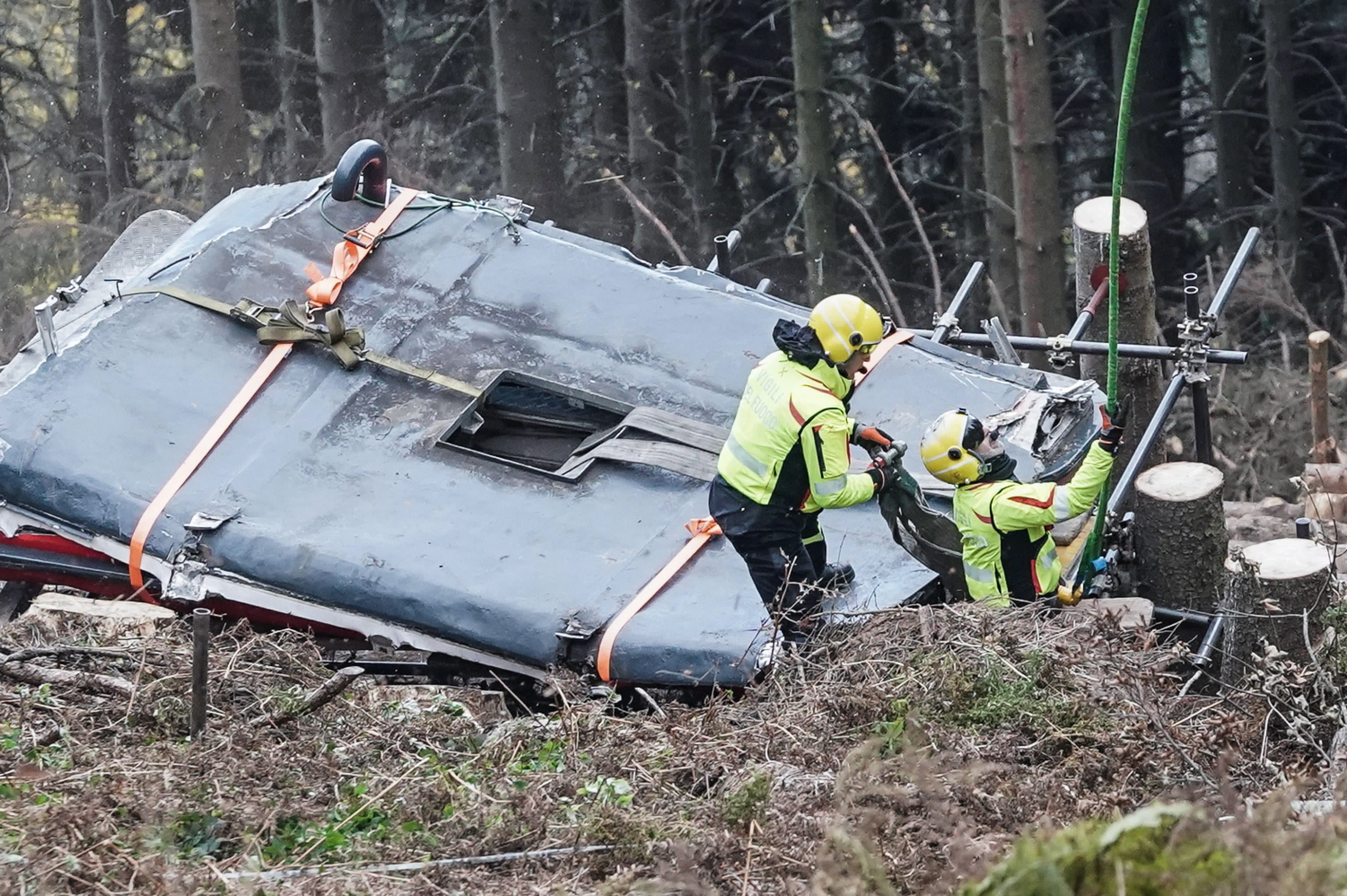 A helicopter prepares to lift the cabin of the cable car that crashed in May in Stresa, Italy