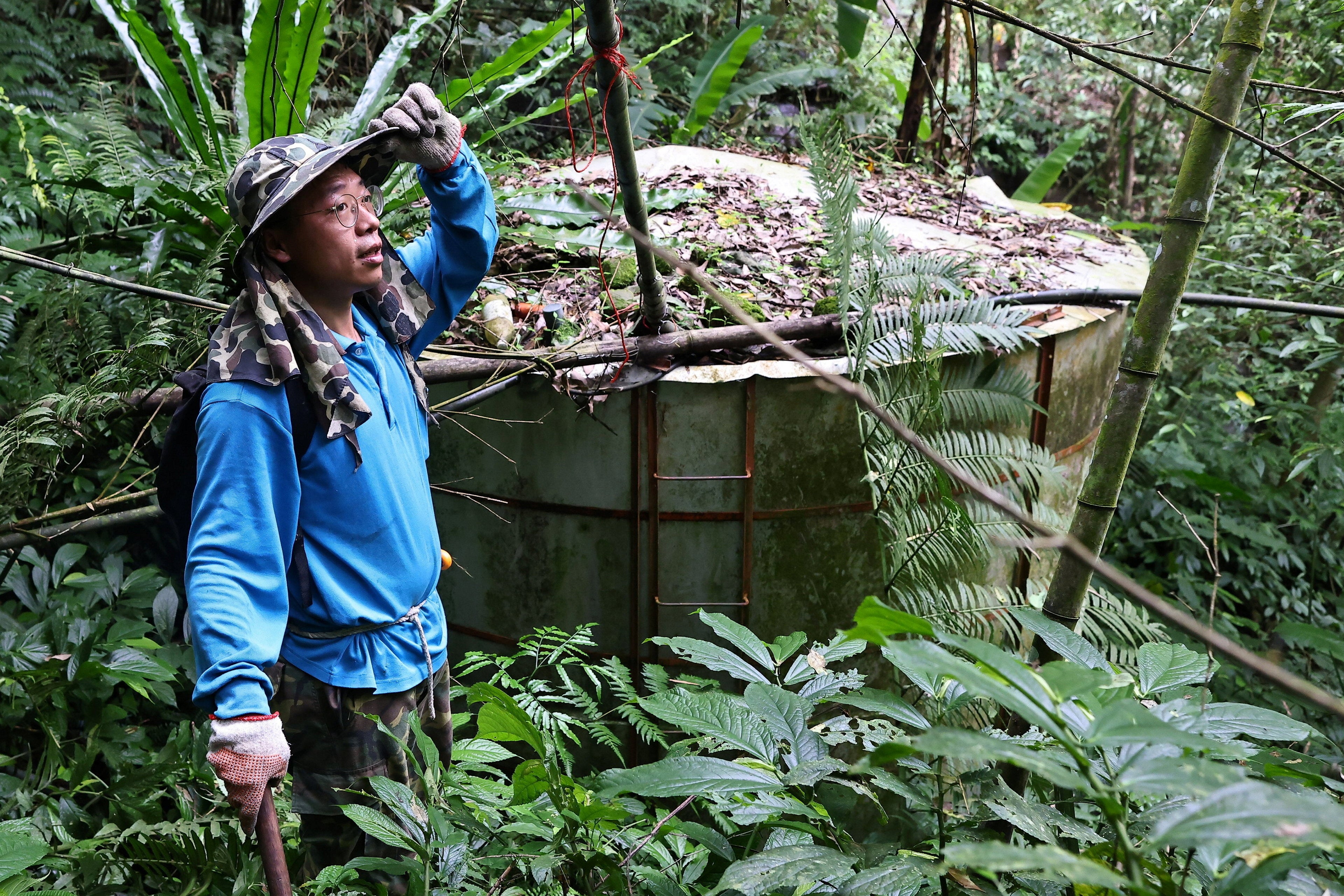 Shun-yih rests after reaching the water tower he built in the middle of the forest