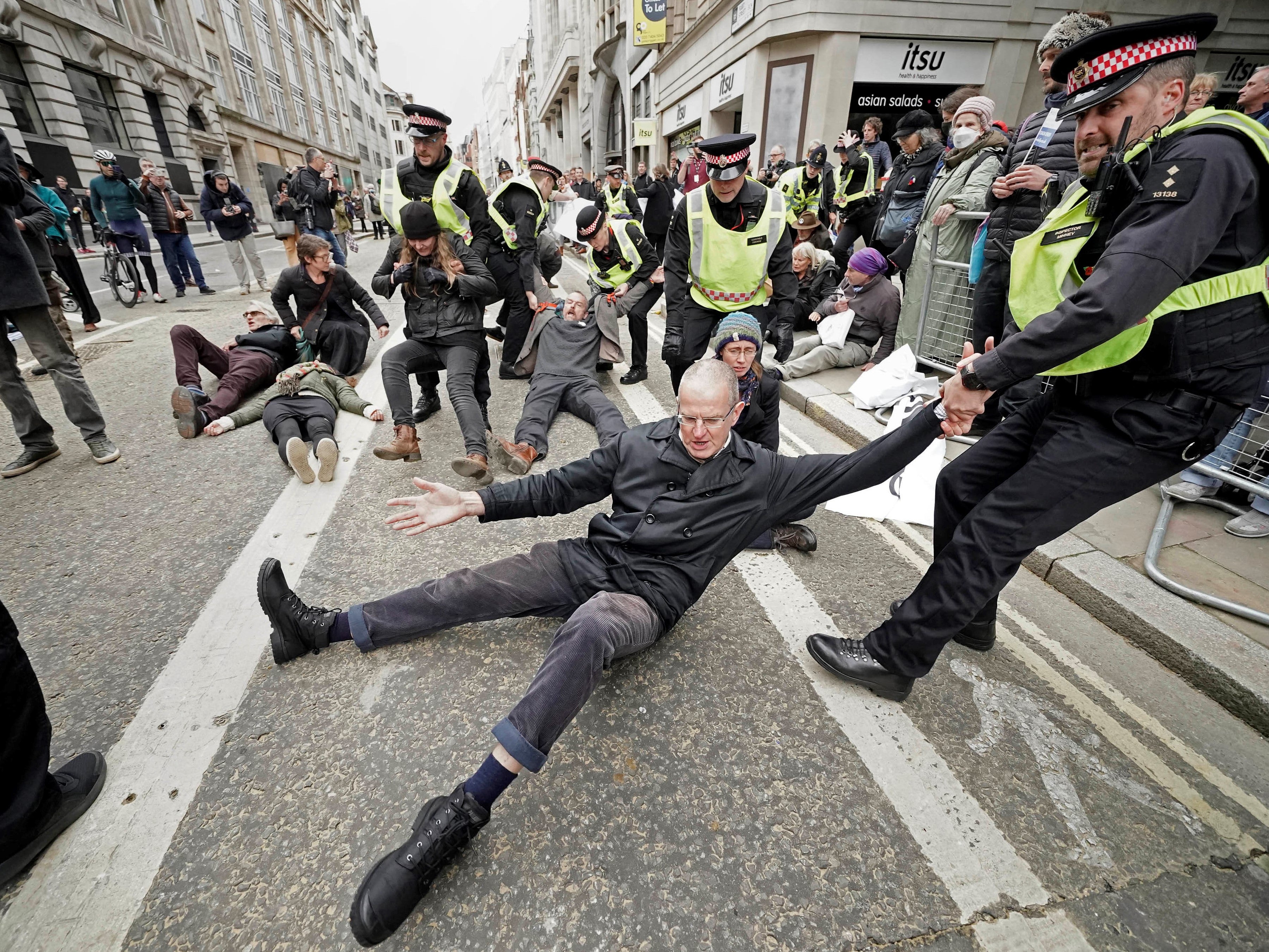 Police remove Extinction Rebellion protesters during the Lord Mayor’s Show parade in the City of London