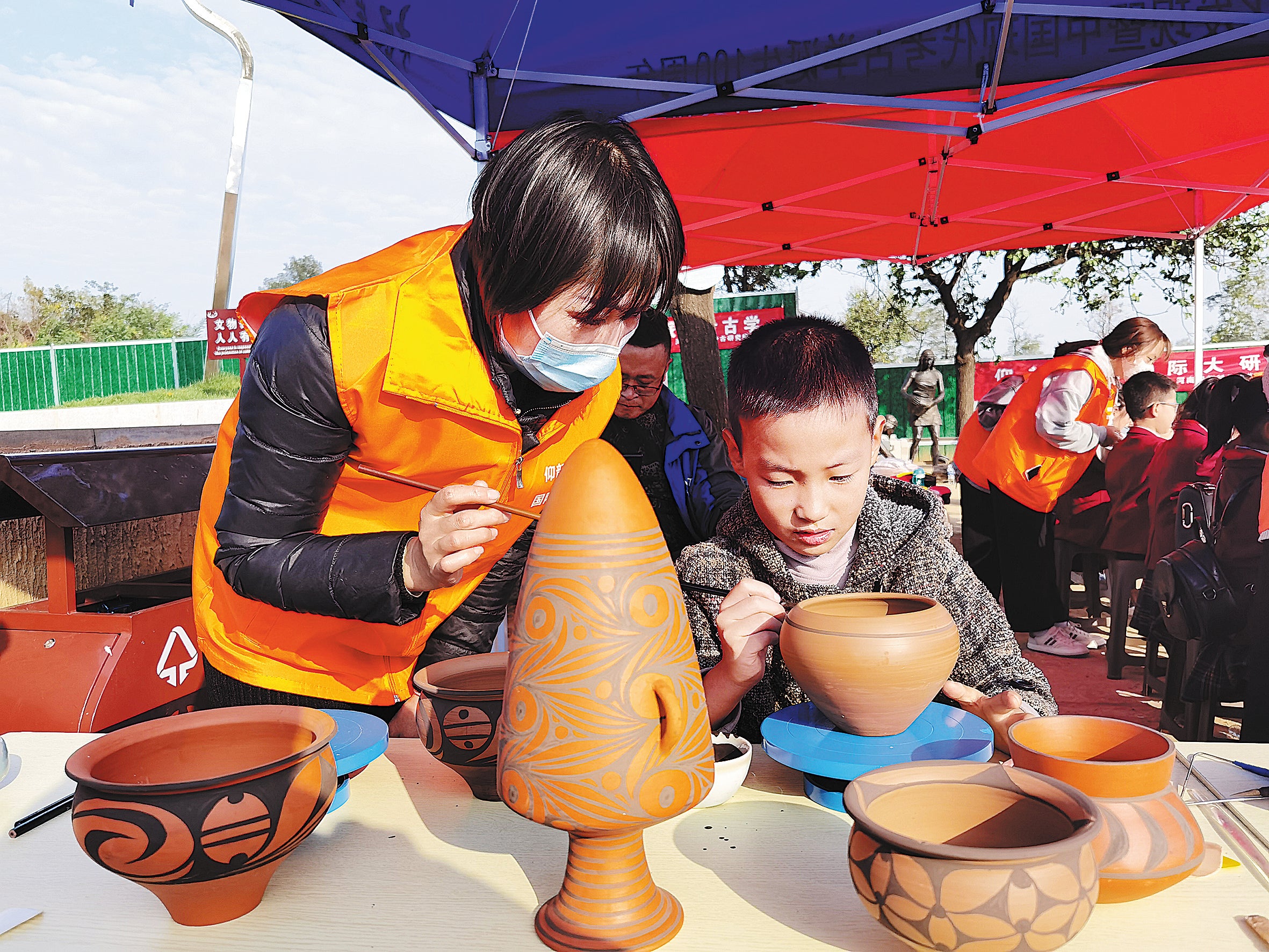 A boy learns to make replica painted pottery at the Yangshao Archaeological Ruins Park in Sanmenxia.