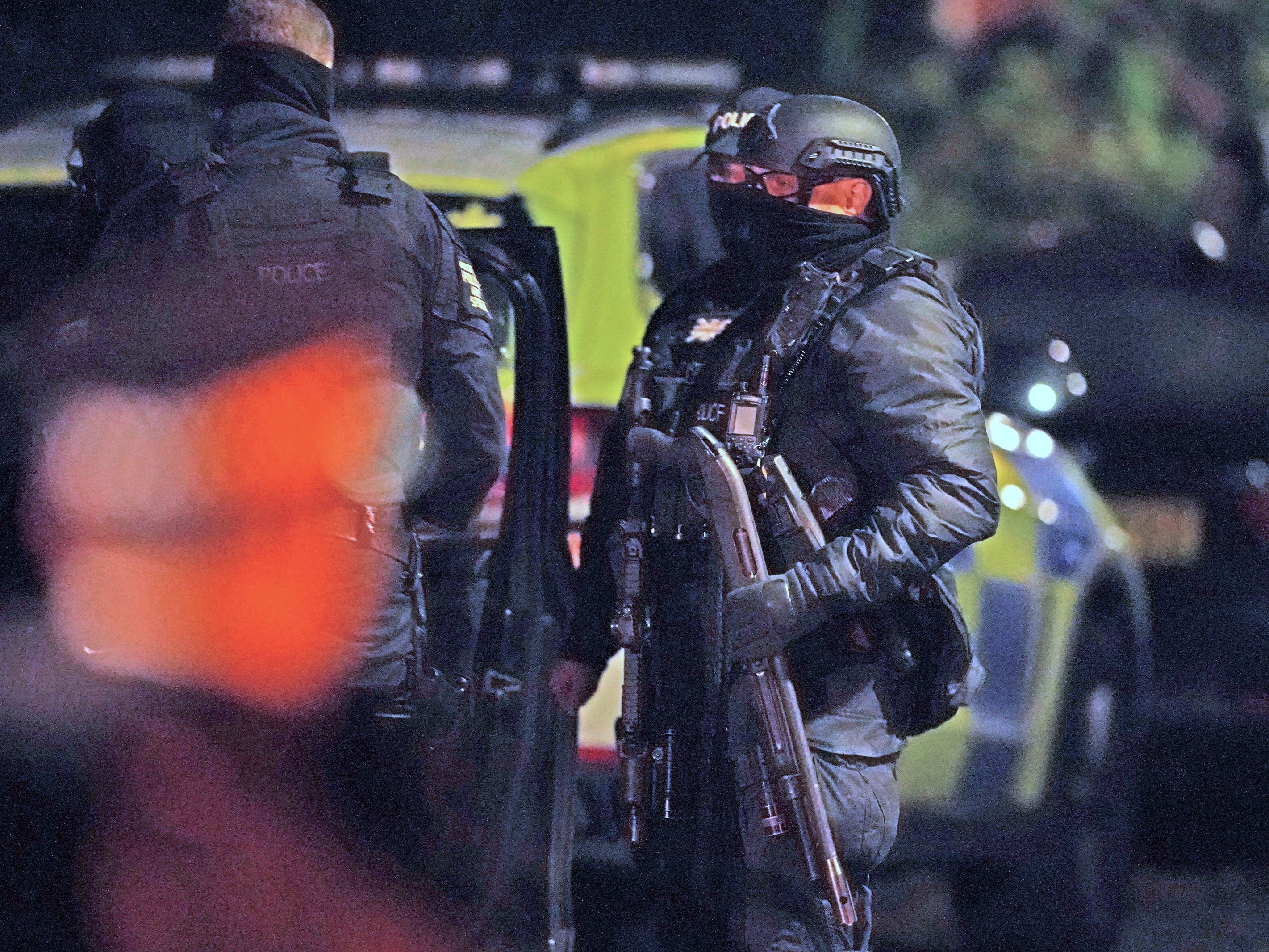 An armed police officer holds a breaching shotgun, used to blast the hinges off a door, at an address in Rutland Avenue in Sefton Park