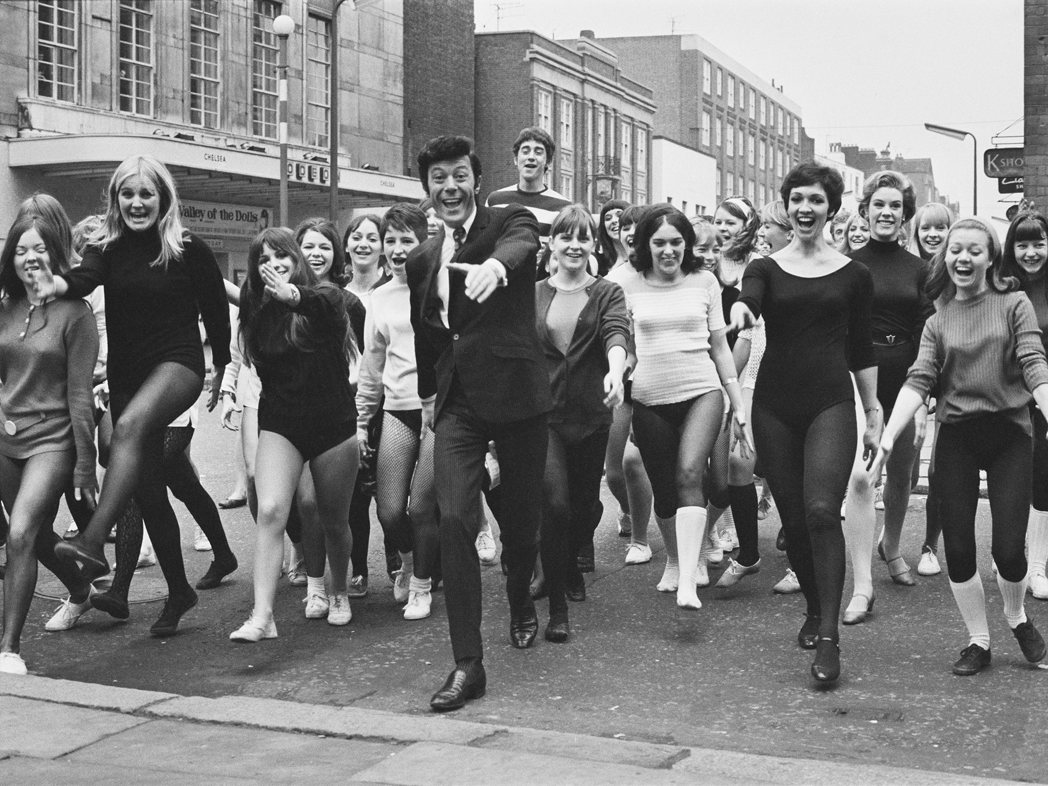 The presenter with a group of aspiring tap dancers auditioning for a show