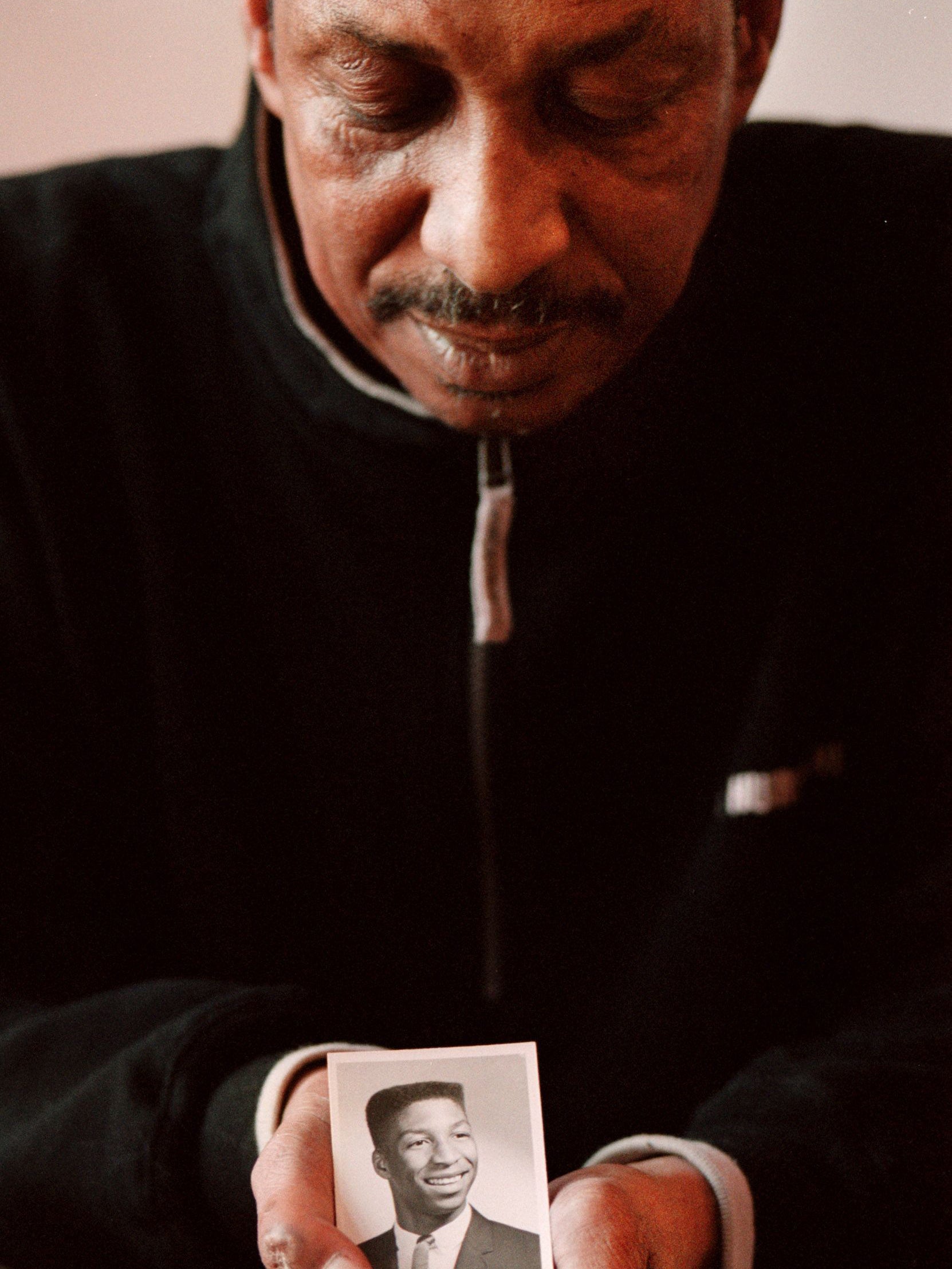 Artis in 2000, holding a picture of himself as a teenager