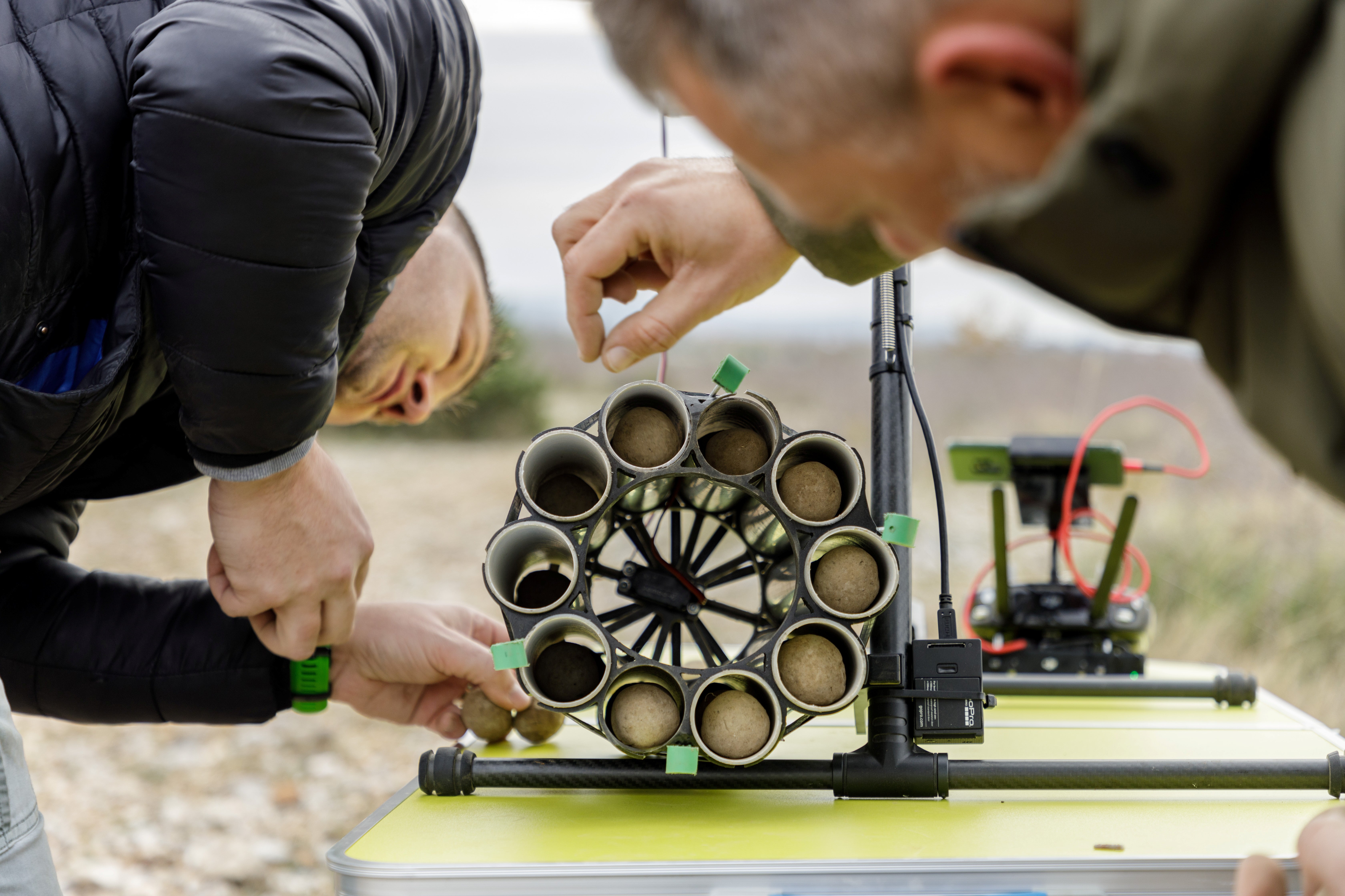 Workers fill a drone with tree seed balls to be scattered in forests in Oklaj