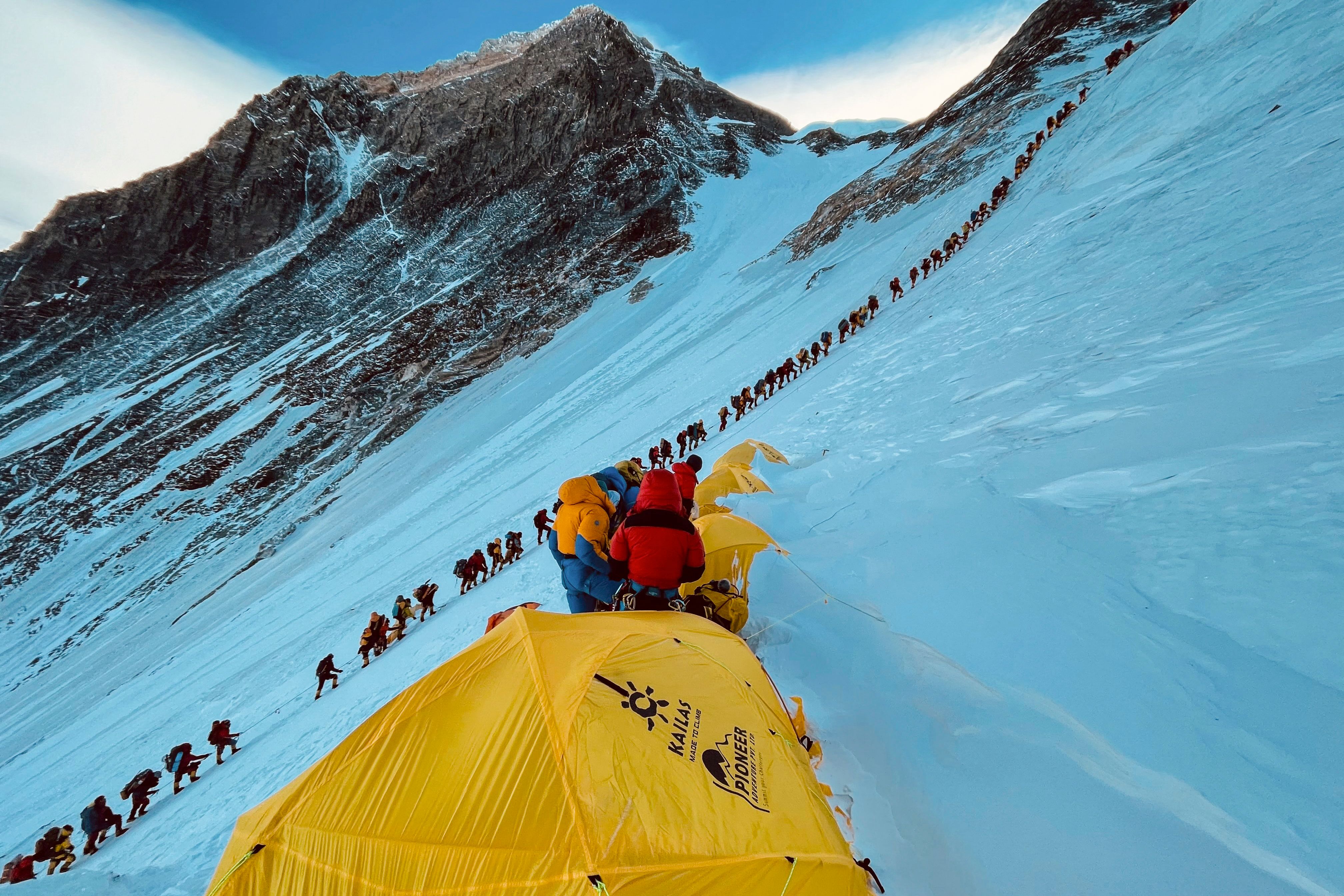 Every year photos go viral of a ‘conga line’ of tourists walking to the top on the easier southern slope of Everest