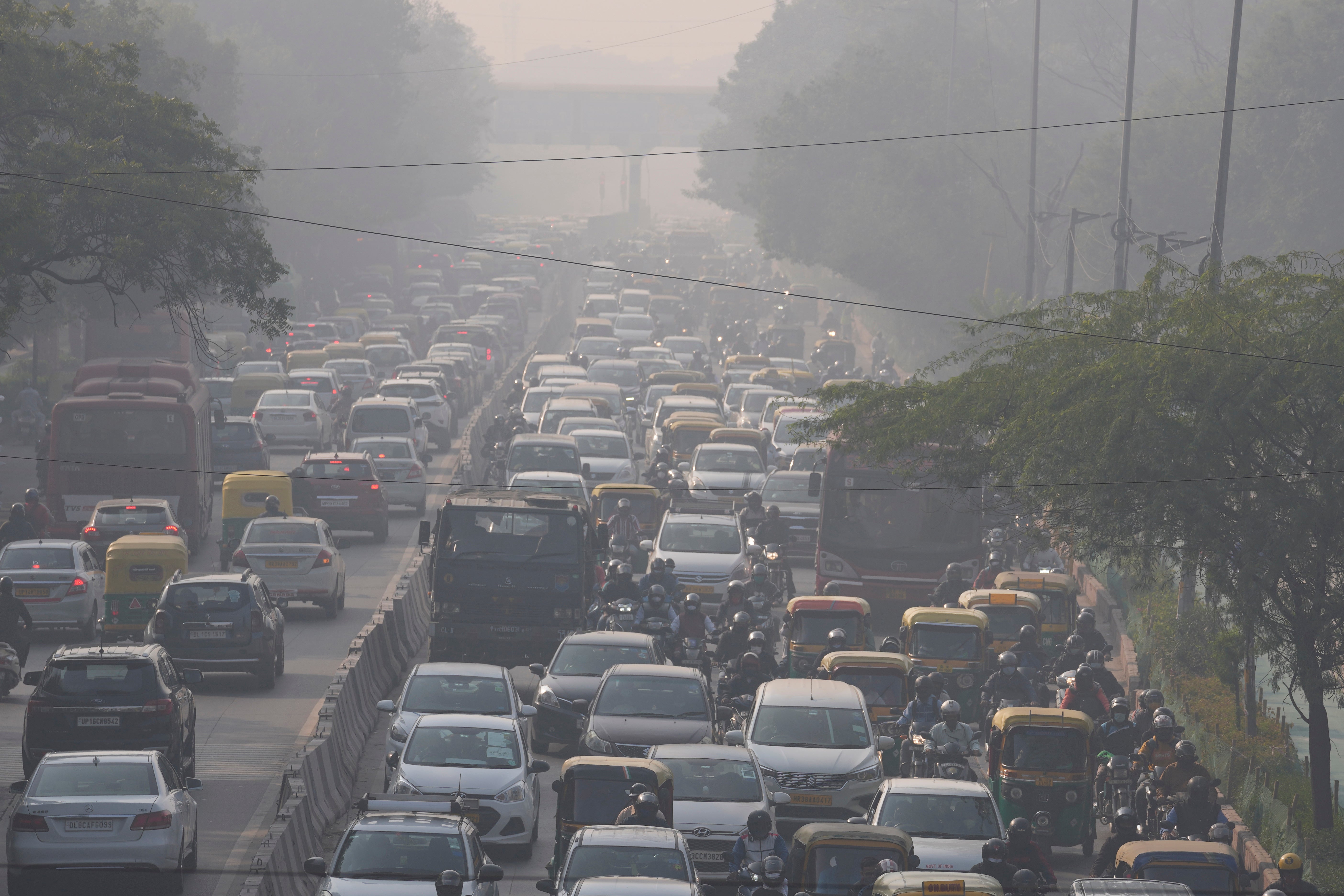 Commuters drive amid the morning haze of toxic smog in New Delhi