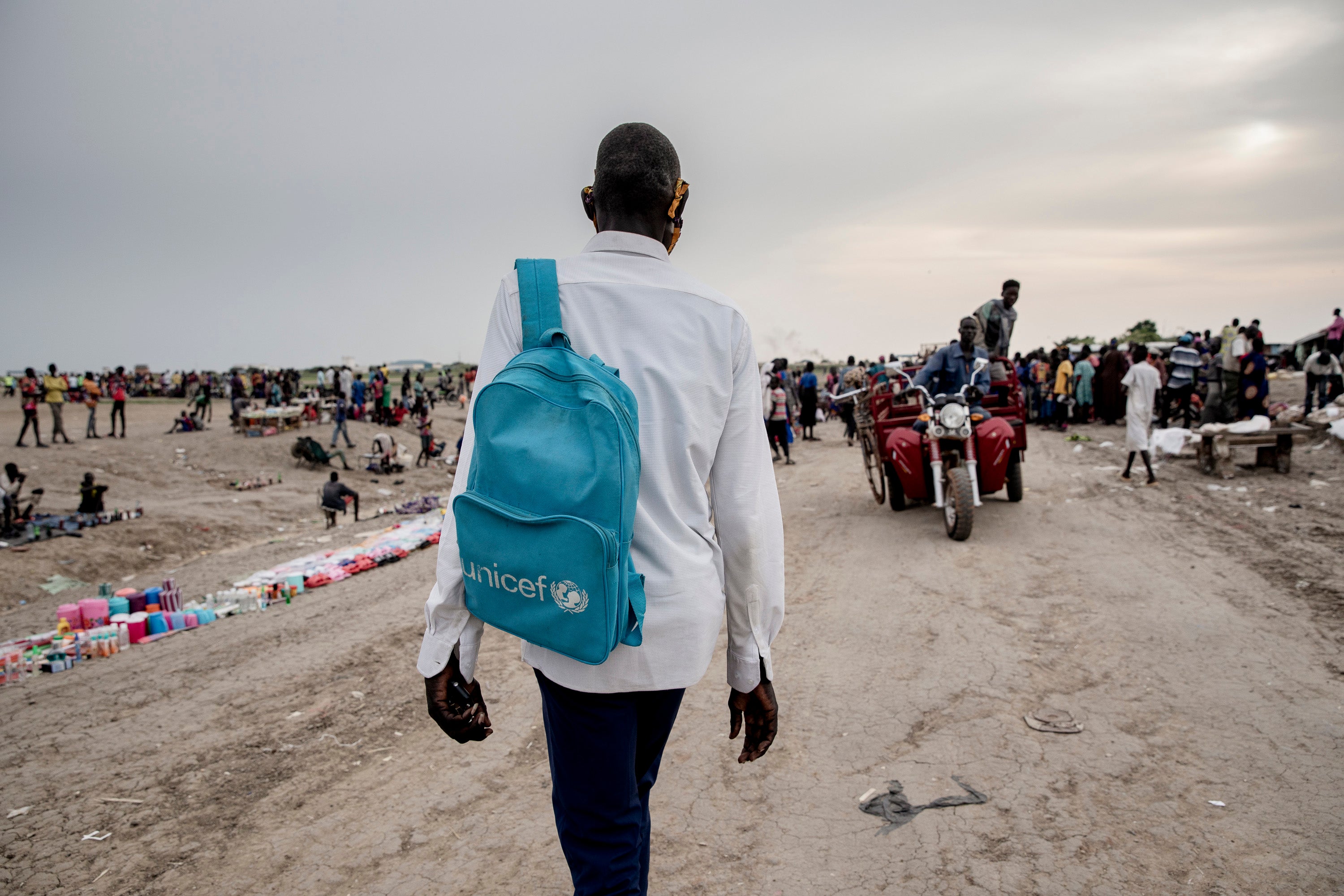 Dhoal Gatwich Gatjani walks to school past the market in the Bentiu camp