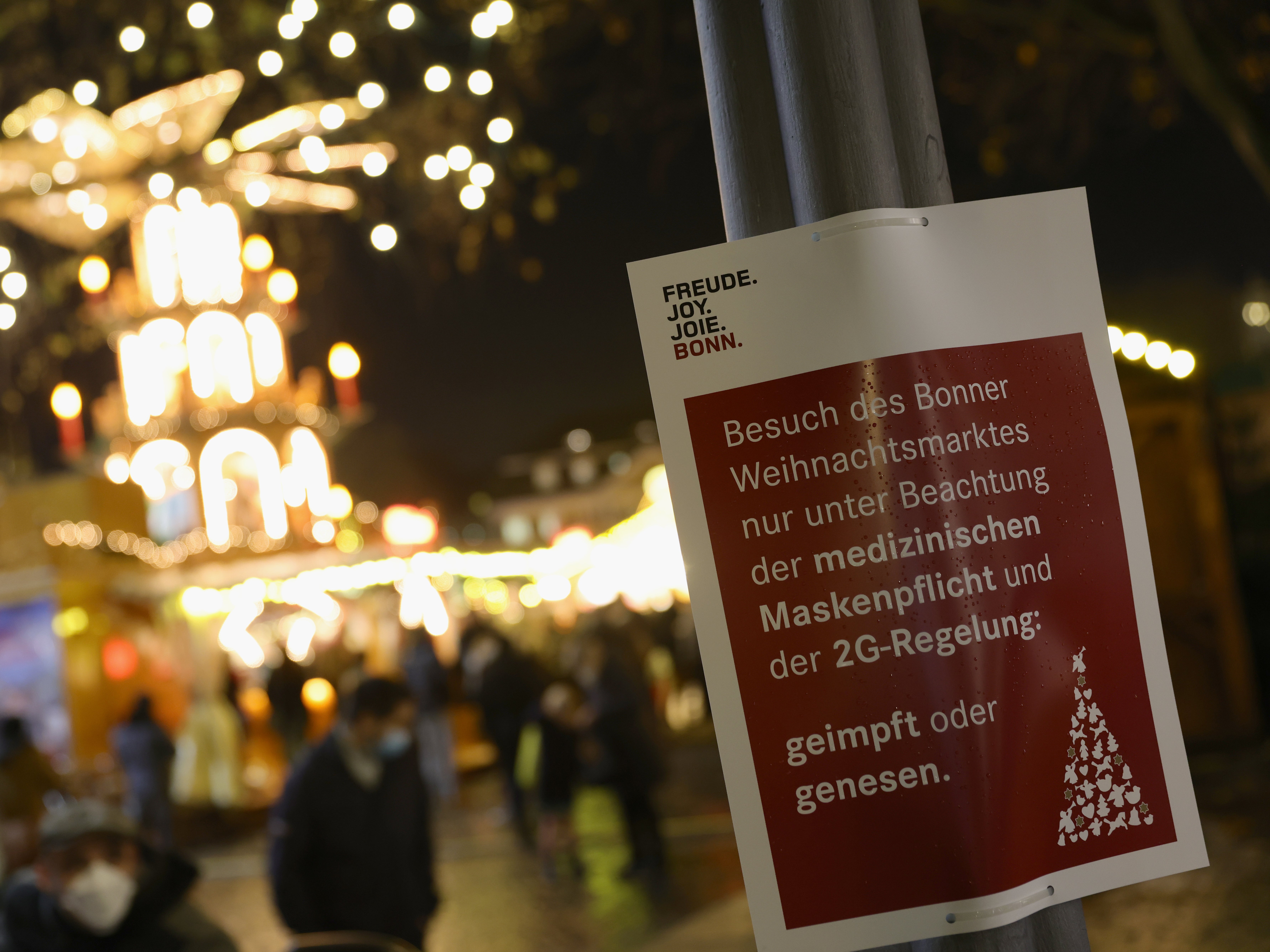 A sign at the annual Christmas market in Bonn, Germany, stating that visitors must wear masks and should be either “vaccinated or recovered”