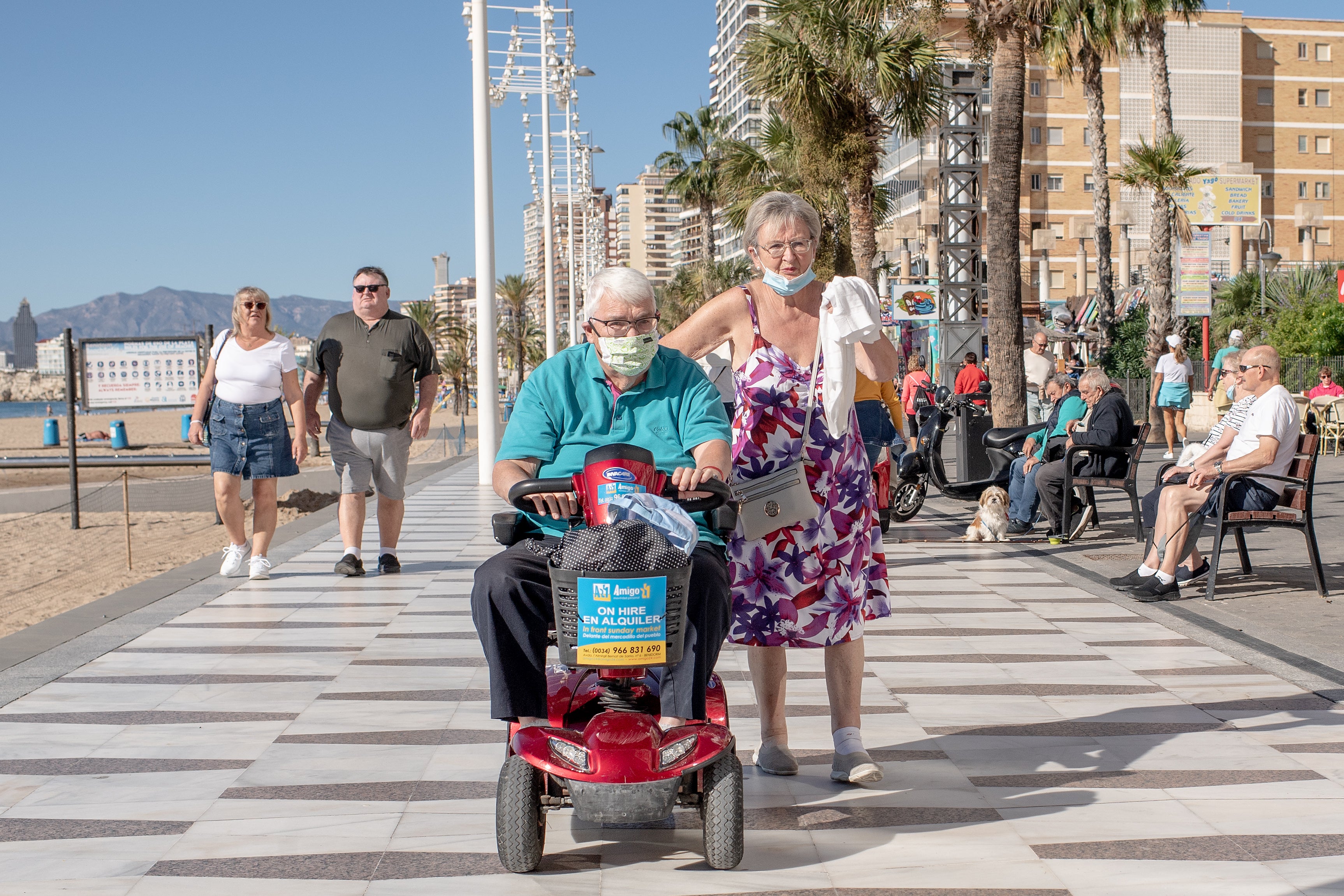 A man drives his mobility scooter along the promenada of Levante beach in Benidorm