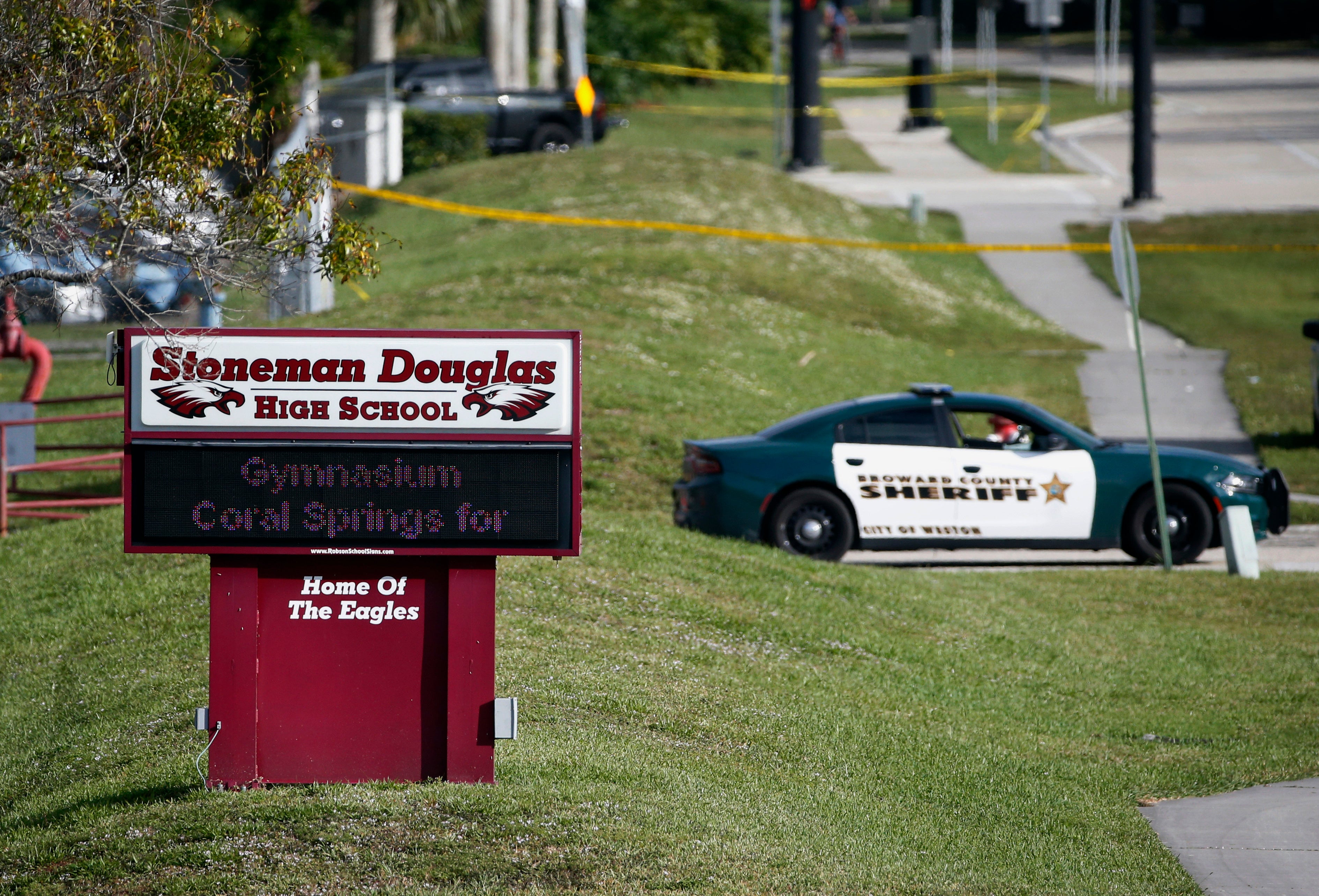 File: Law enforcement officers block off the entrance to Marjory Stoneman Douglas High School after the shooting in 2018