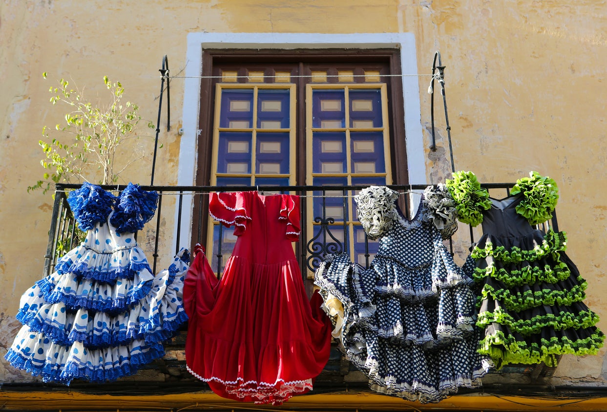 Flamenco dresses hang from a balcony