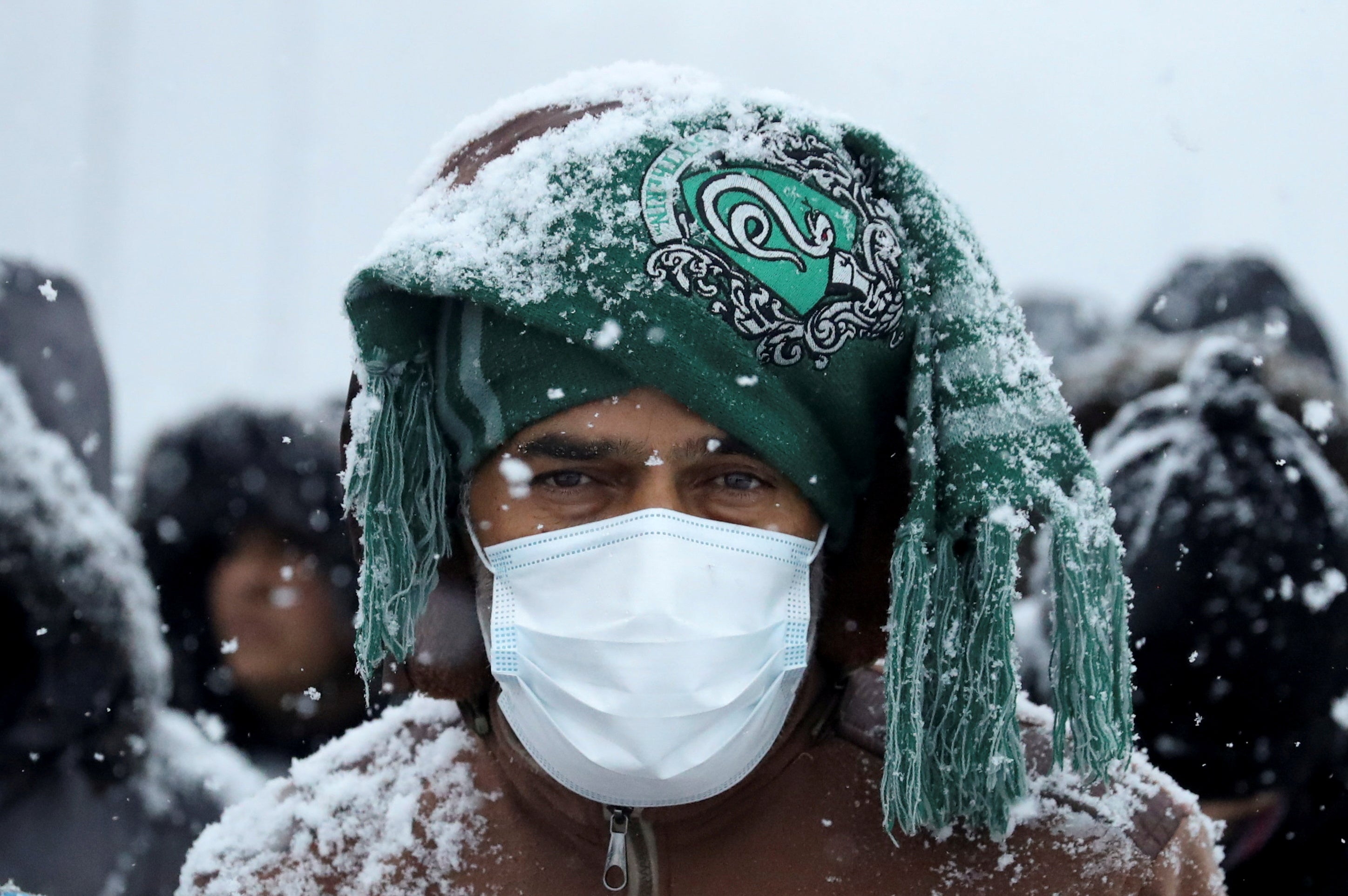 Migrants gather at a transport and logistics centre during snowfall, near the Belarusian-Polish border