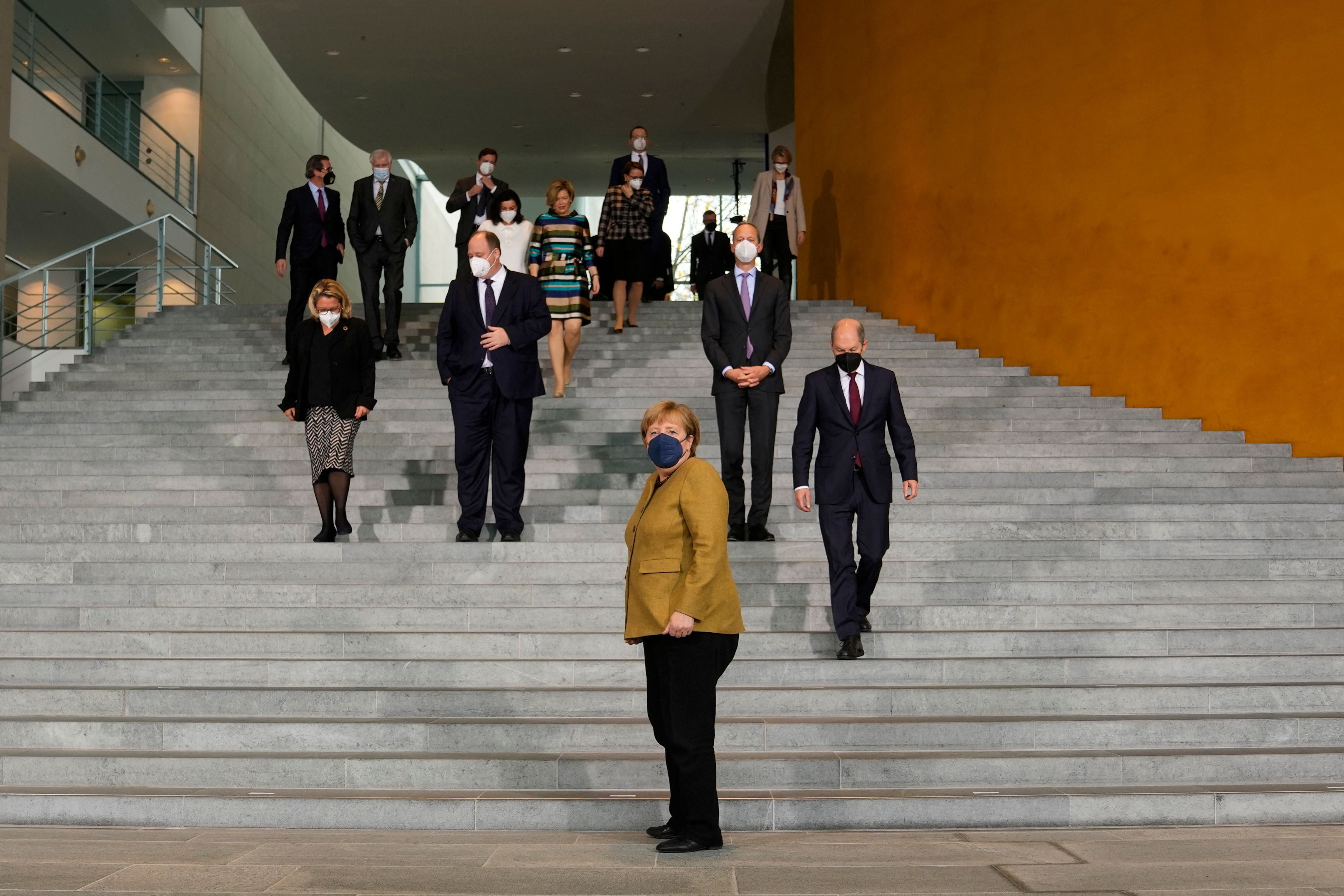 German chancellor Angela Merkel arrives for a group photo with ministers and other members of her government after the cabinet meeting at the Chancellery on Wednesday