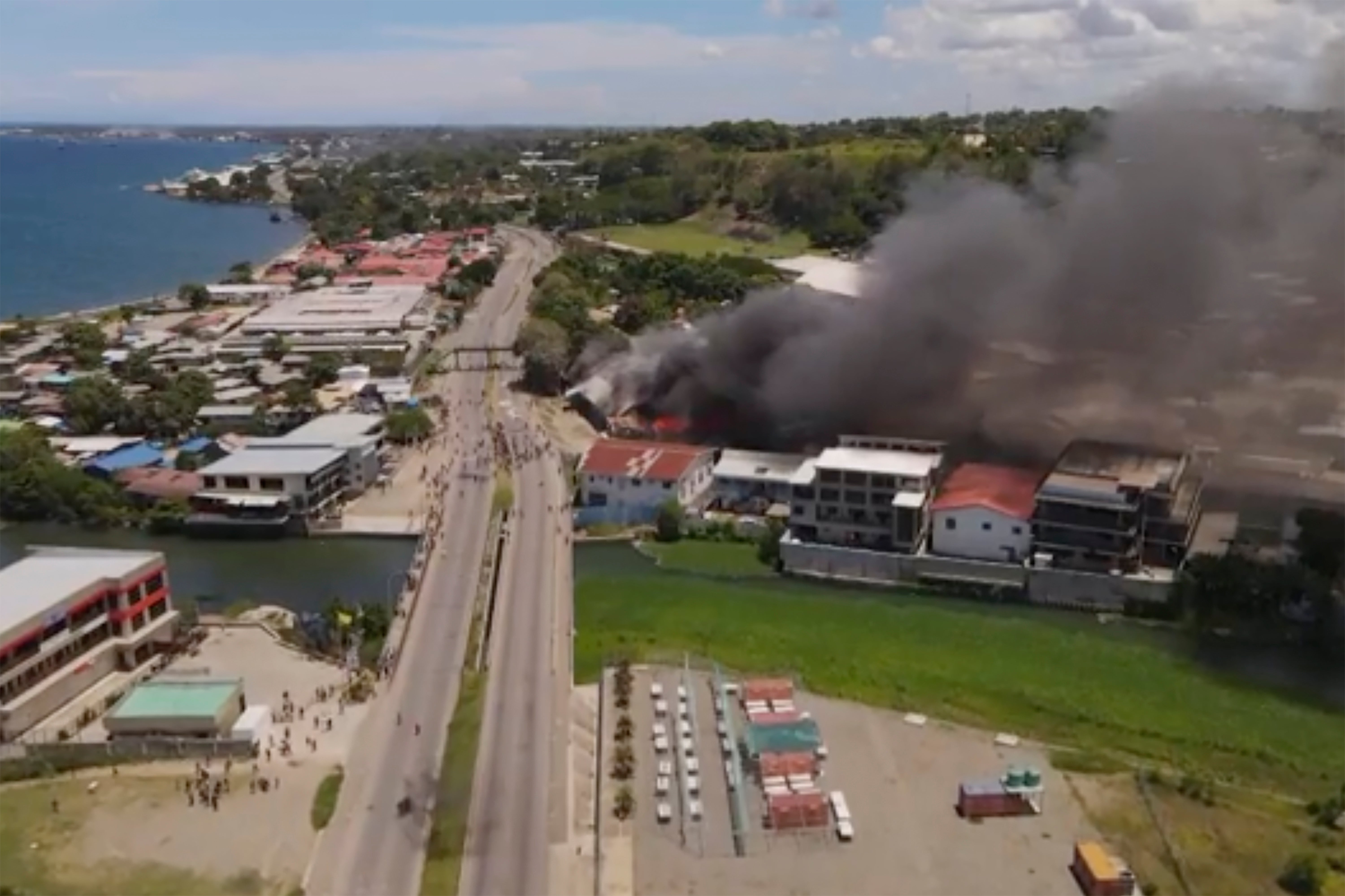 Smoke rises from burning buildings during a protest in Honiara