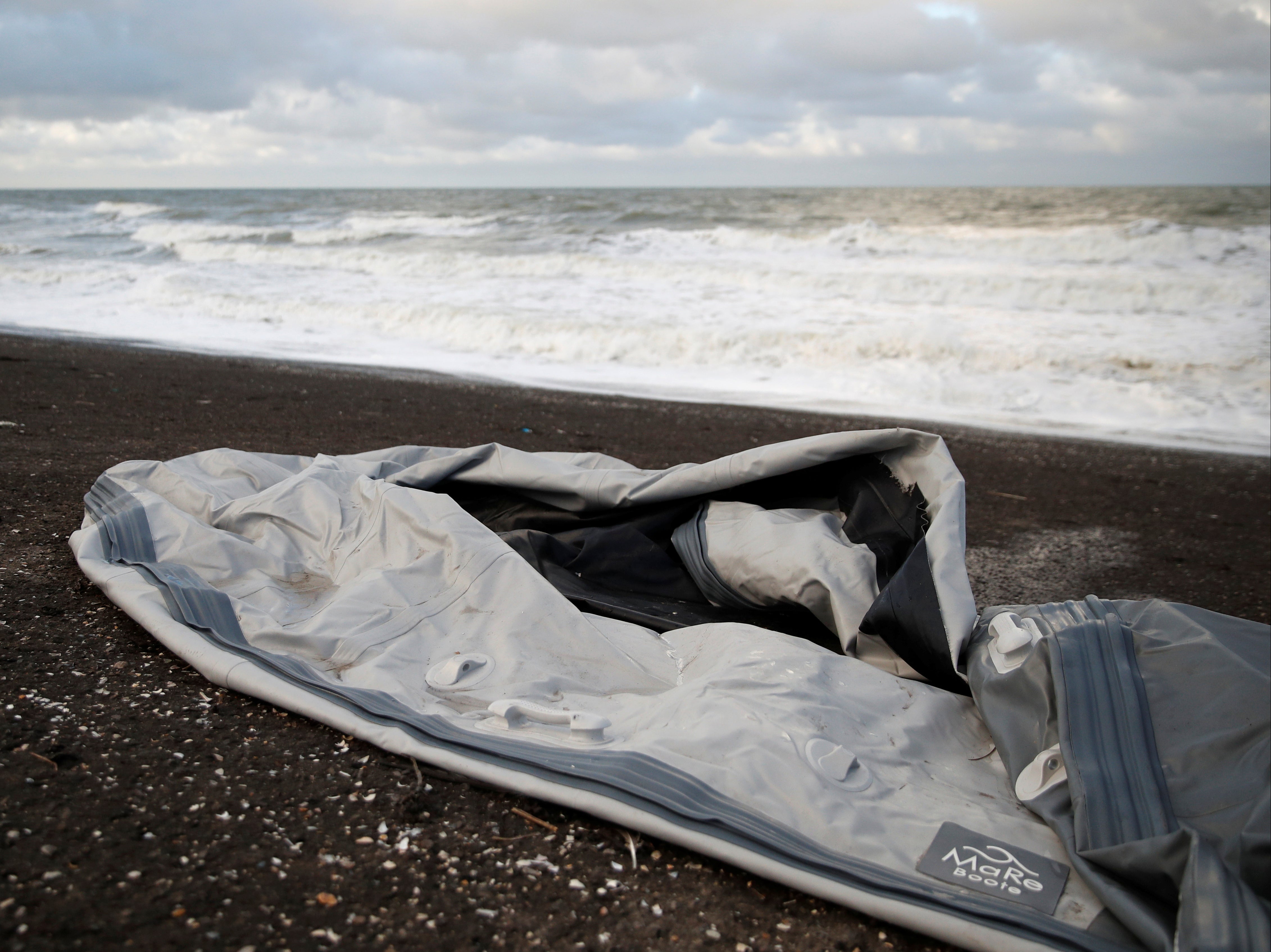 A damaged inflatable dinghy is seen on Loon Beach, the day after 27 migrants died when their dinghy deflated as they attempted to cross the English Channel