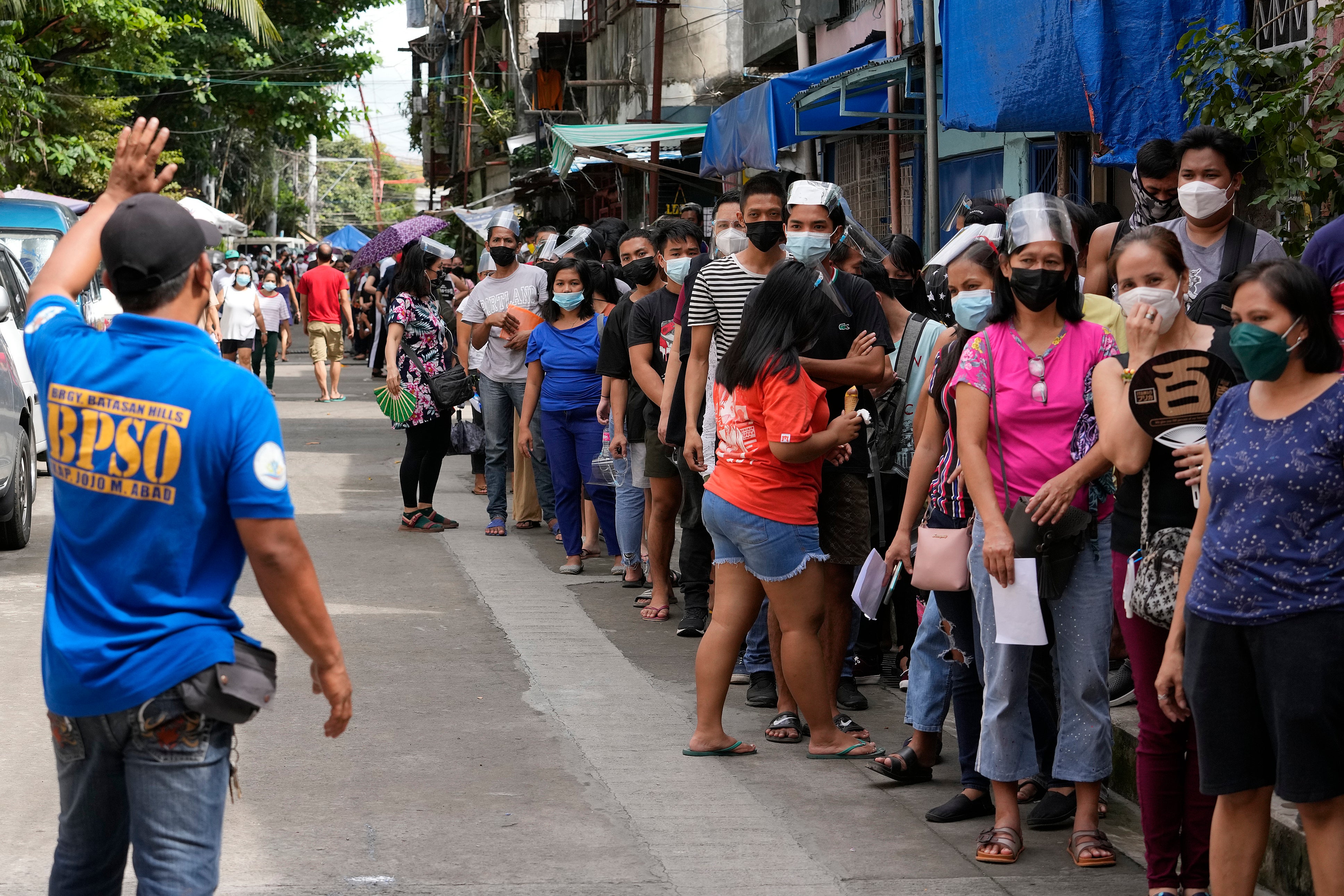 People in Quezon city wait for Covid-19 vaccines during a nationwide three-day vaccination drive