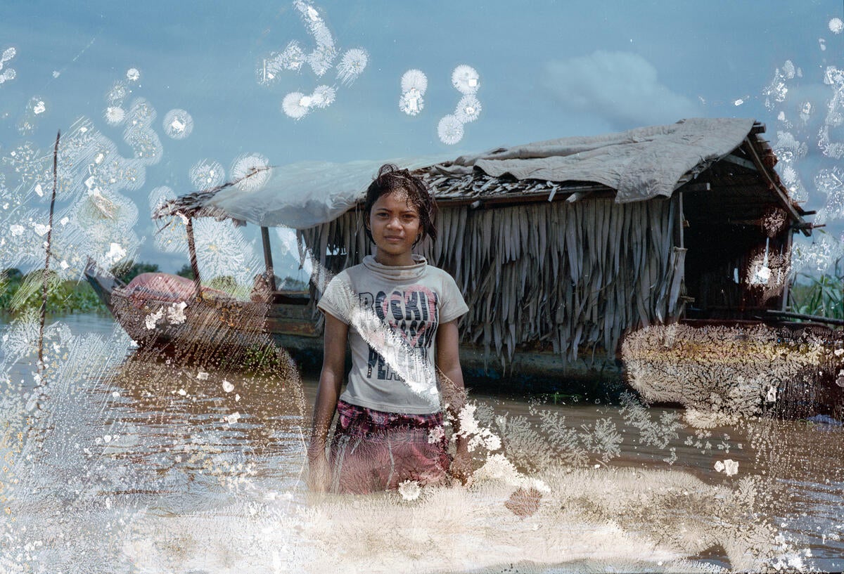 Chenla, 15, stands in the water near her houseboat on Tonle Sap lake