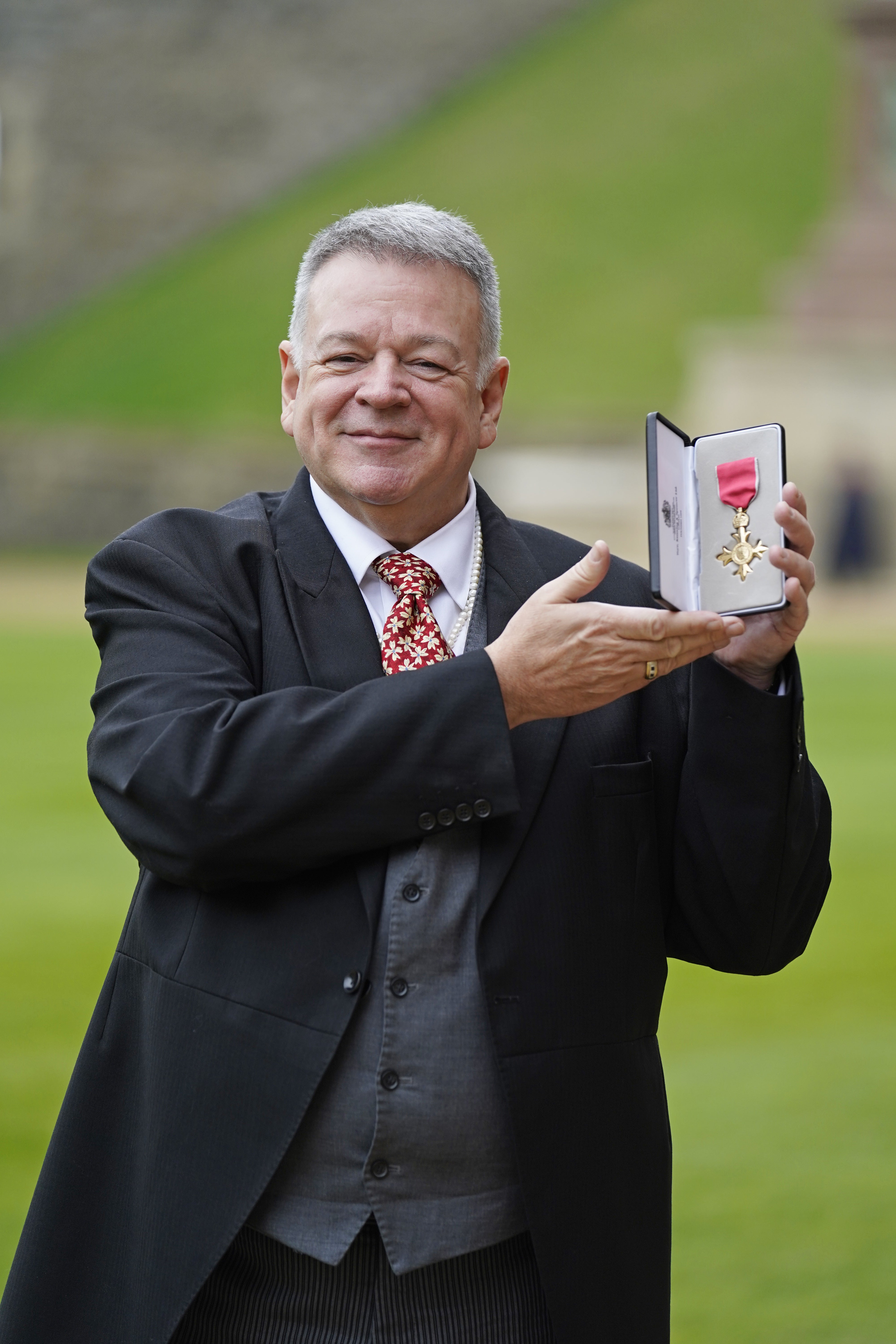 Professor Nicholas Daniel shows off his OBE (Andrew Matthews/PA)