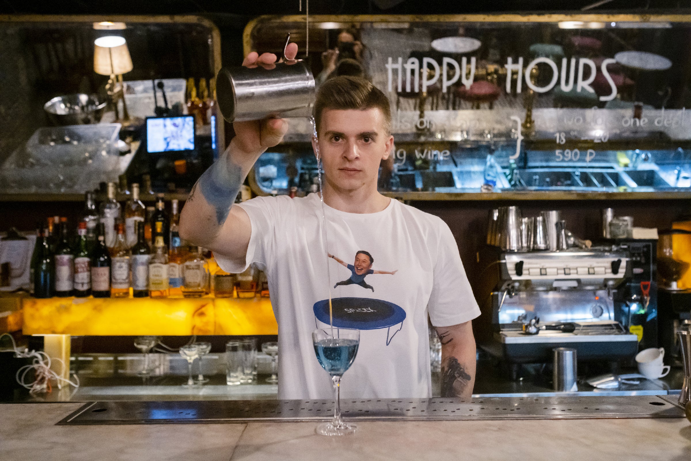 Bartender Pavel Antonov in a trampolining Elon Musk T-shirt pouring his Mars cocktail