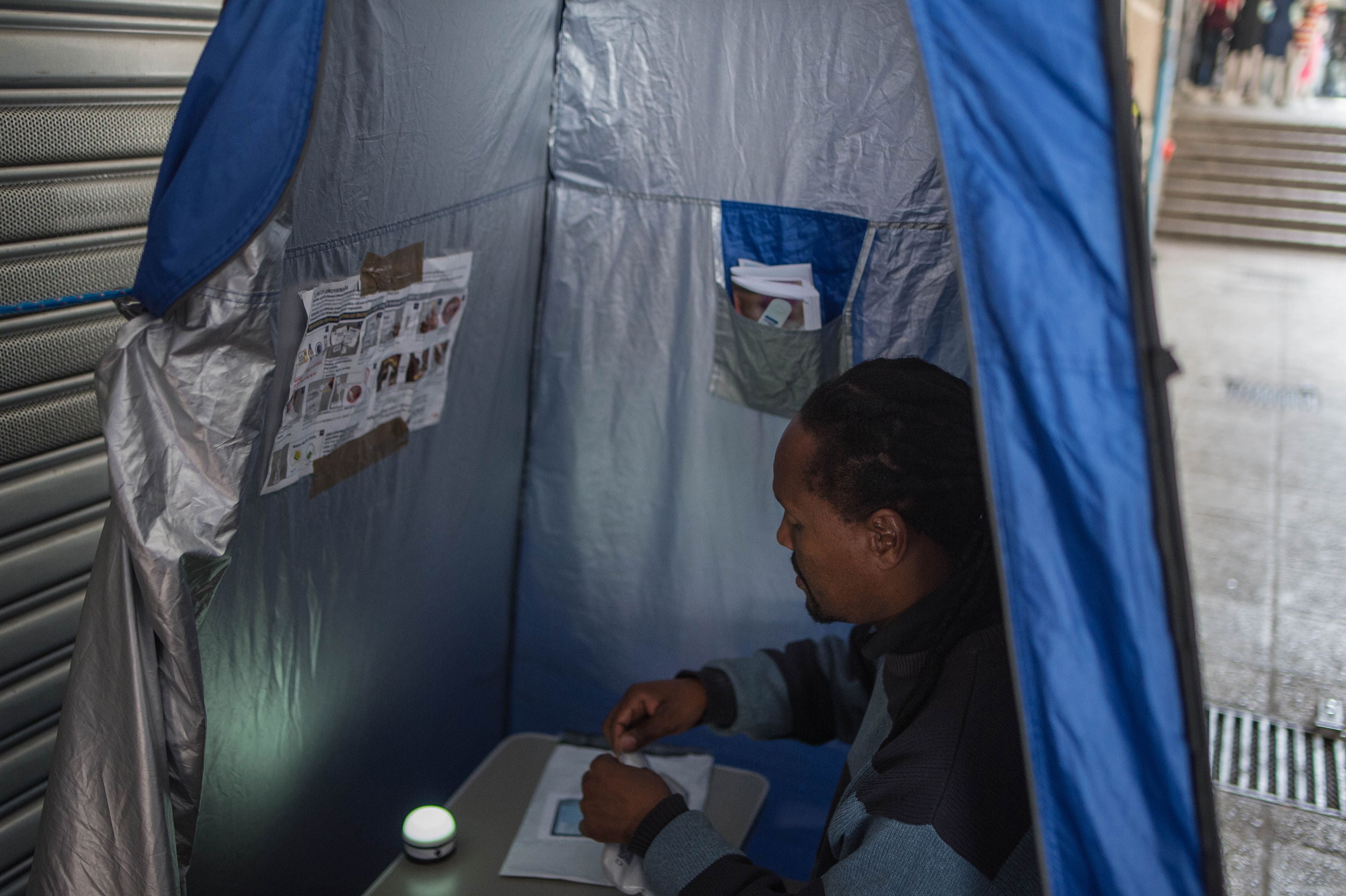 A man uses an HIV self-testing kit, administered by students from the University of the Witwatersrand in Hillbrow, Johannesburg