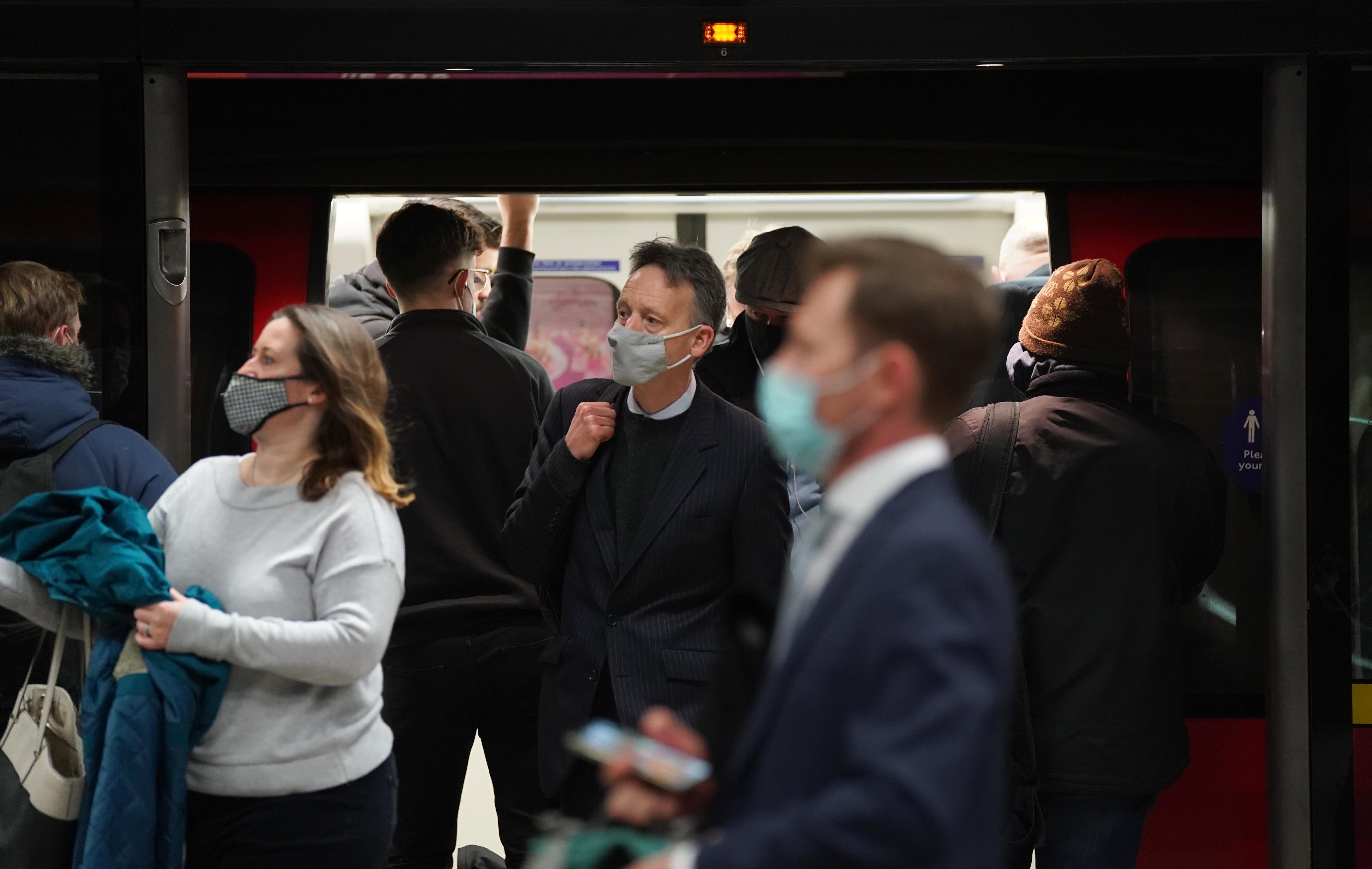 People wear masks while travelling on the London Underground (Stefan Rousseau/PA)