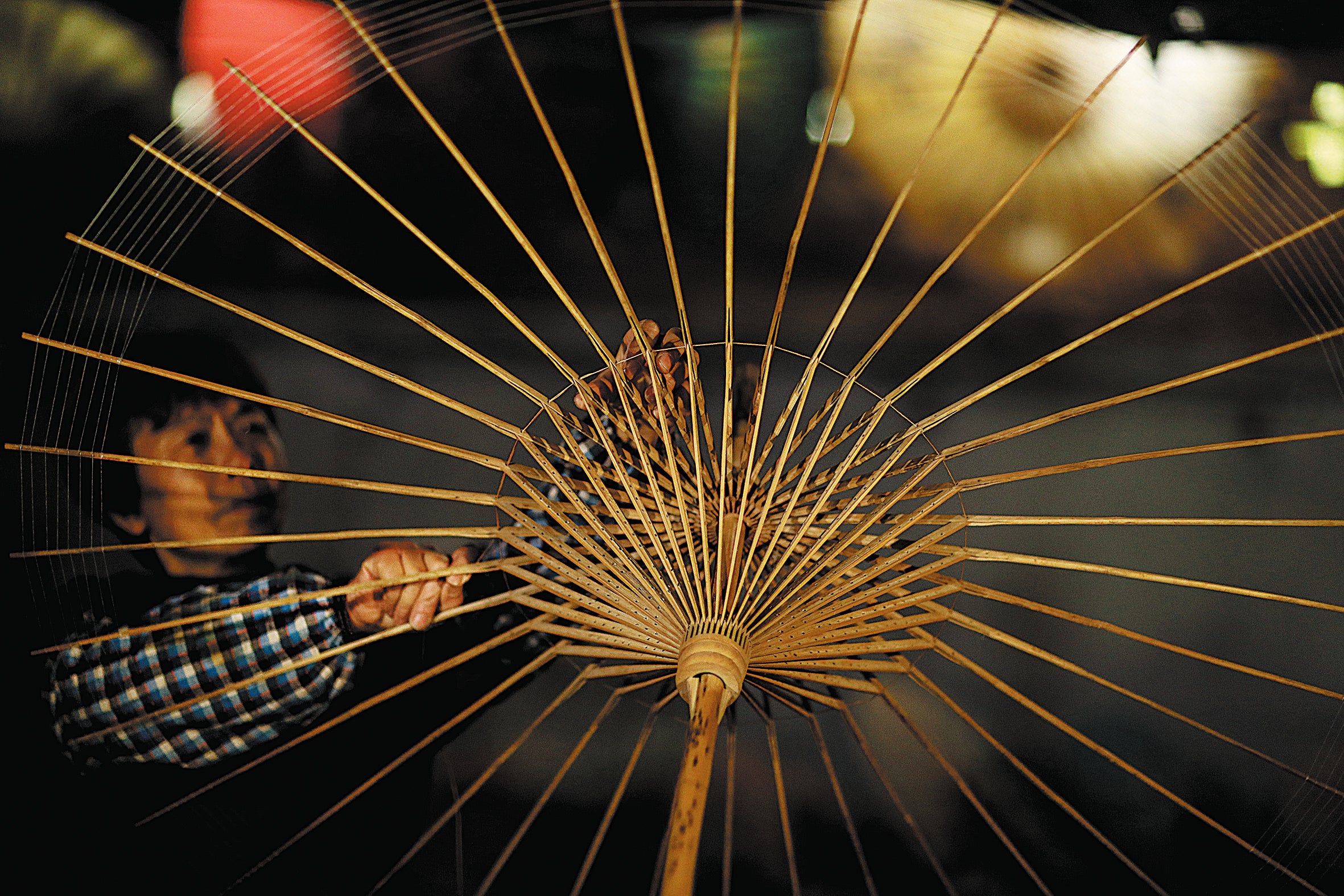 Li works on an oilpaper umbrella at her store