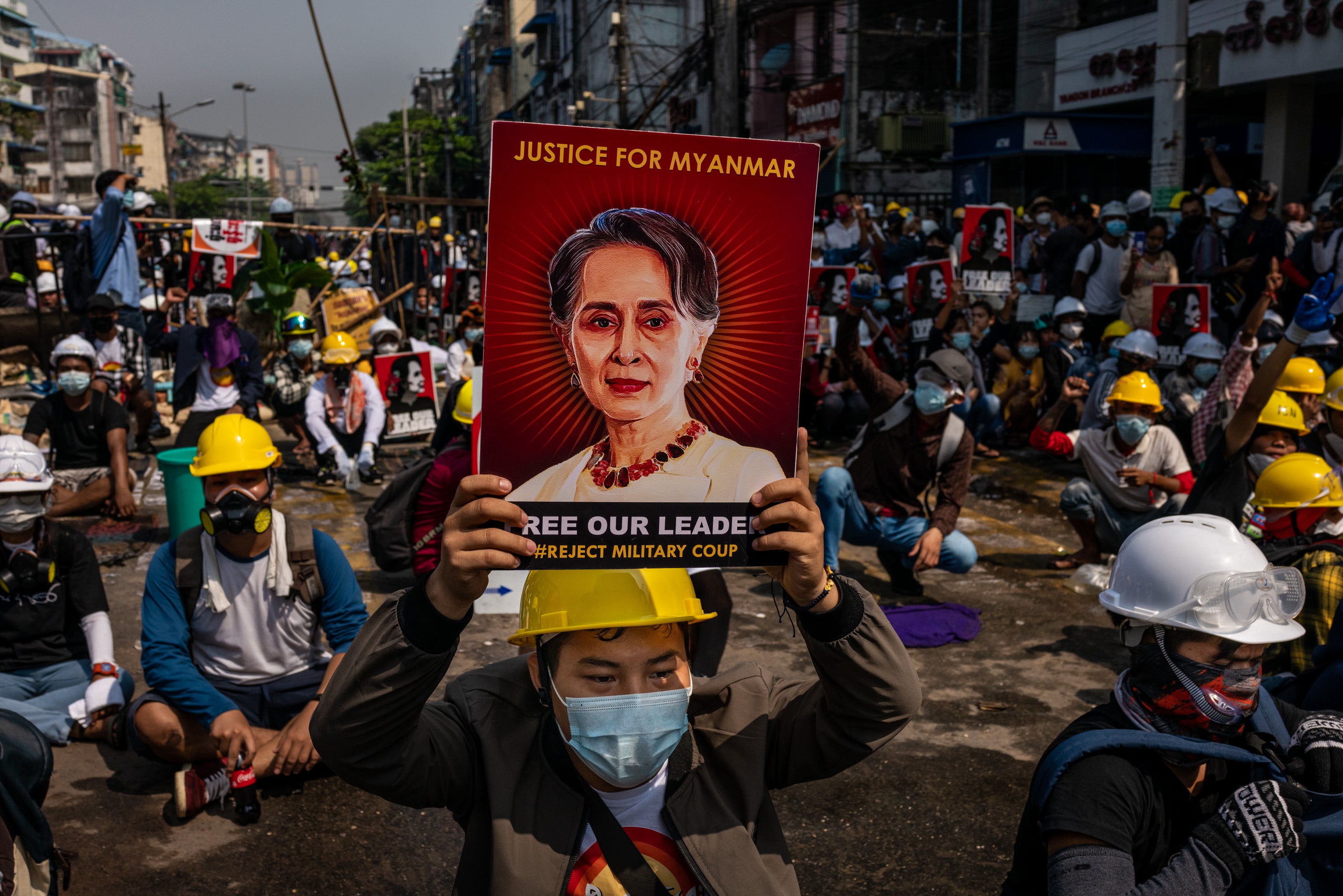 An anti-coup protester holds up a placard featuring de-facto leader Aung San Suu Kyi