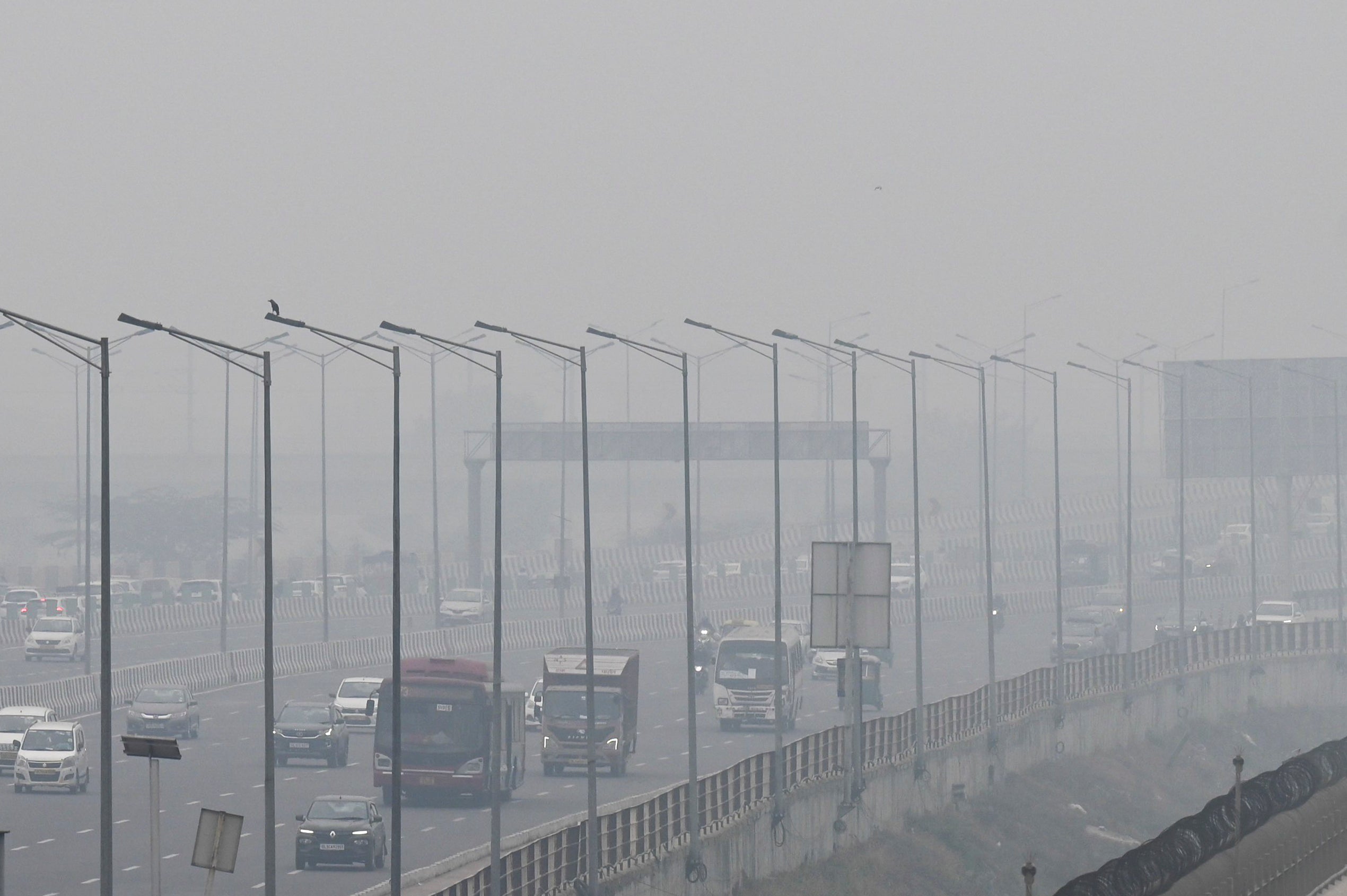 People commute along a street amid smoggy conditions in India’s national capital New Delhi on 2 December 2021