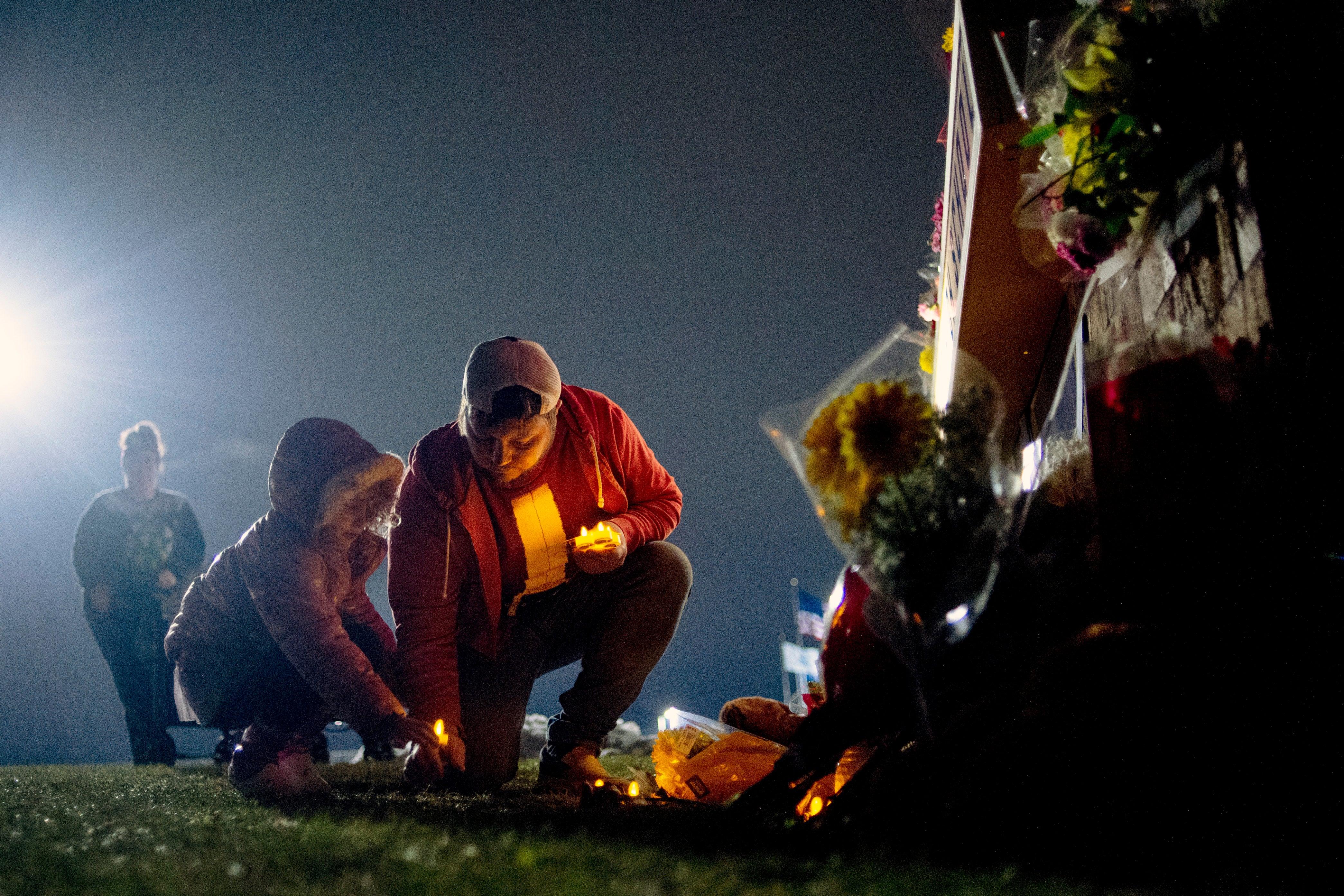 Waterford resident Andrew Baldwin, cousin of Madisyn Baldwin, places candles at the base of a a memorial with his 5-year-old daughter Ariyah Baldwin