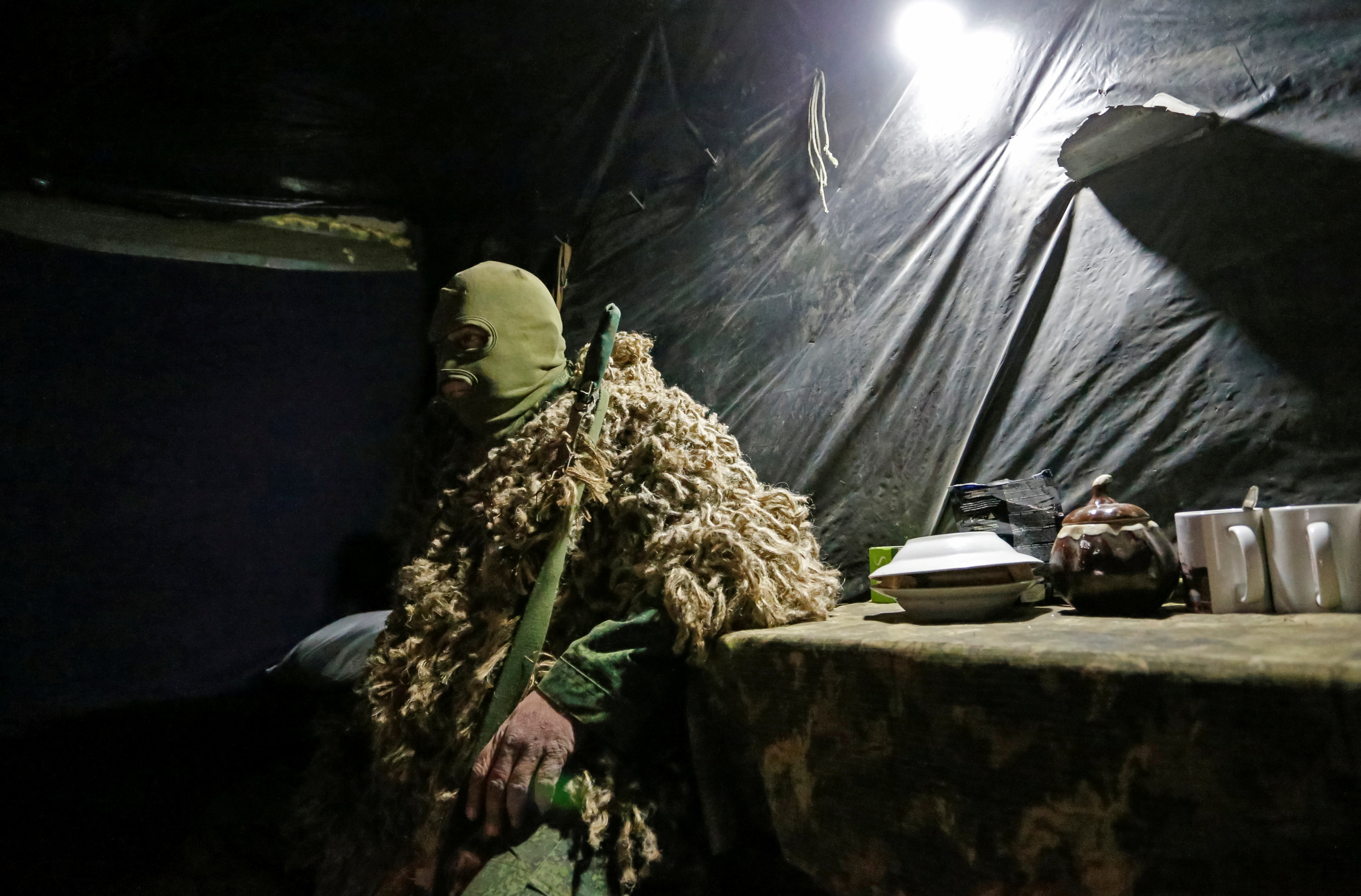 A sniper from the self-proclaimed Donetsk People’s Republic (DNR) sits at a fighting position on the line of separation from the Ukrainian armed forces outside the rebel-controlled city of Donetsk, Ukraine