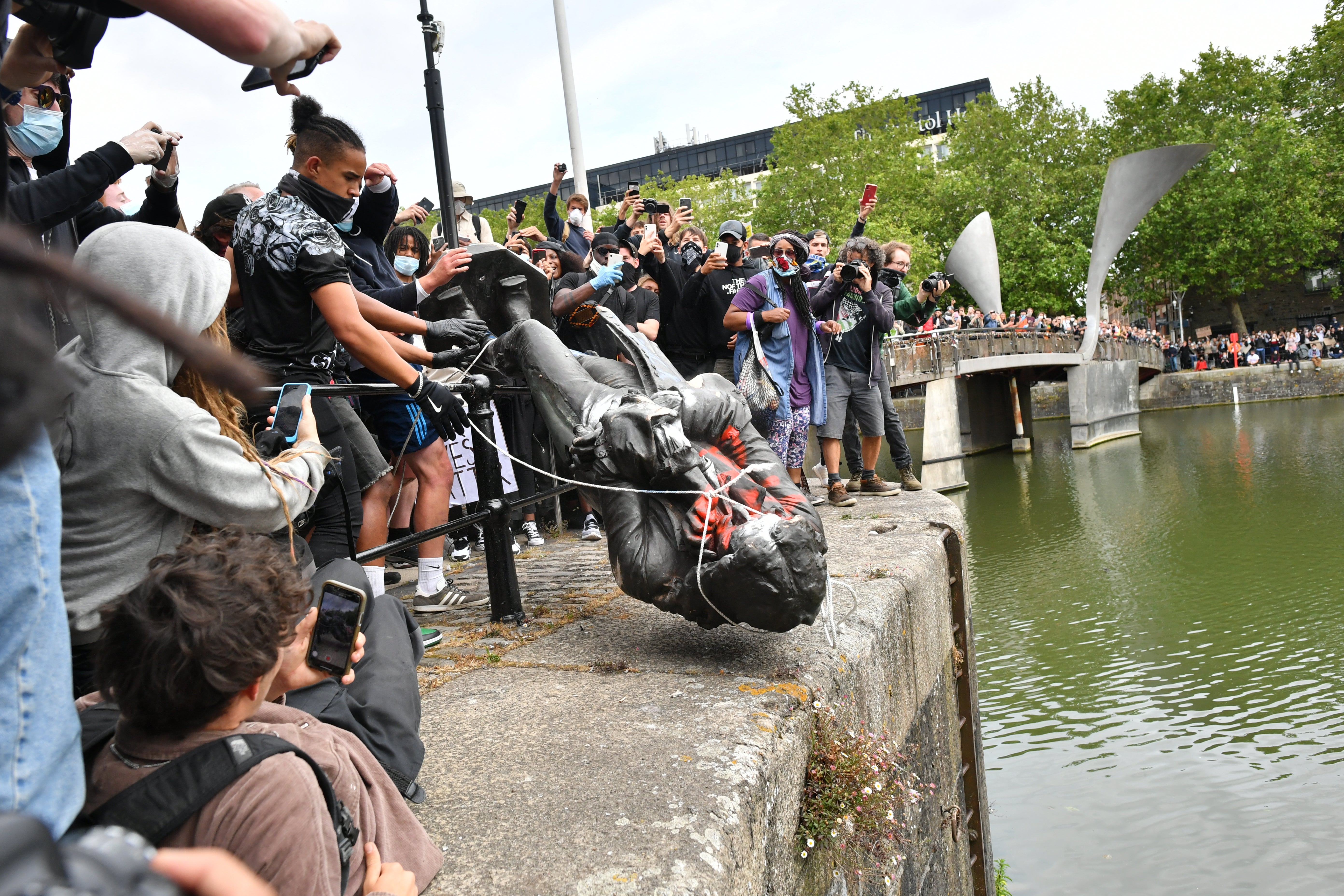 Protesters throw the statue of Edward Colston into Bristol harbour (PA)