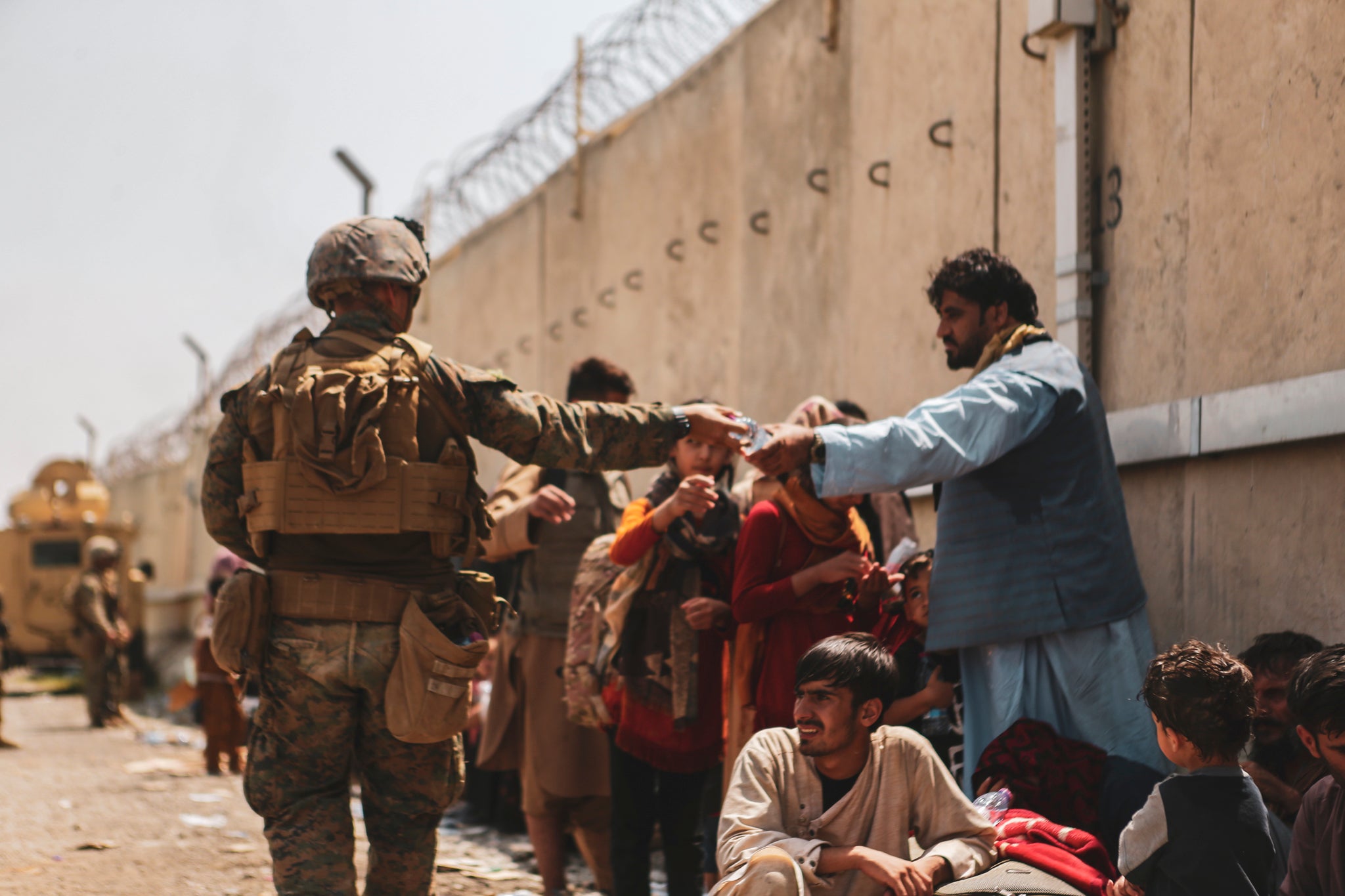 A US marine passes out water to evacuees during the evacuation of Kabul in 2021