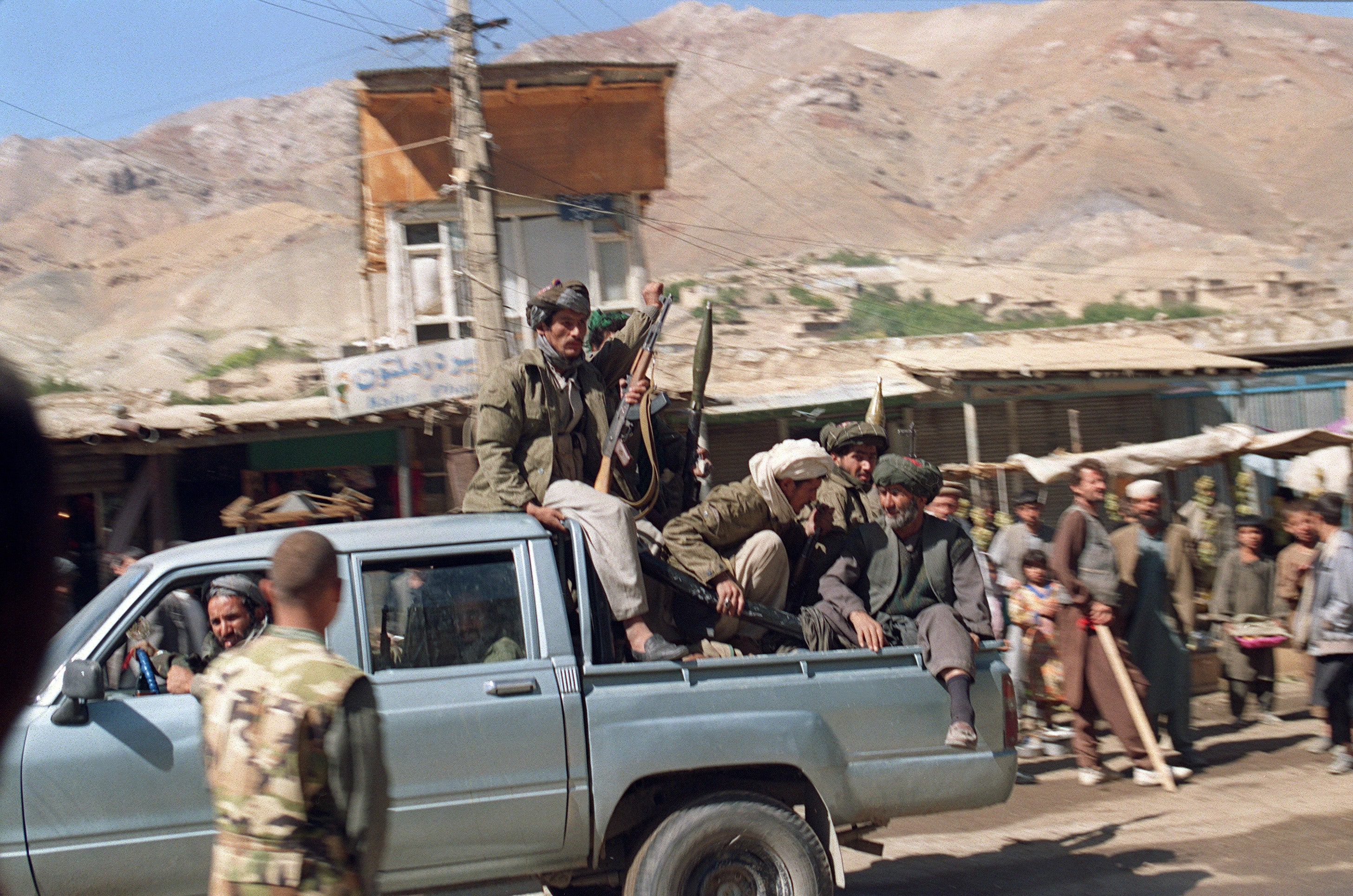 Armed troops belonging to the Taliban militia head towards the frontline of Panjsher Valley in 1996