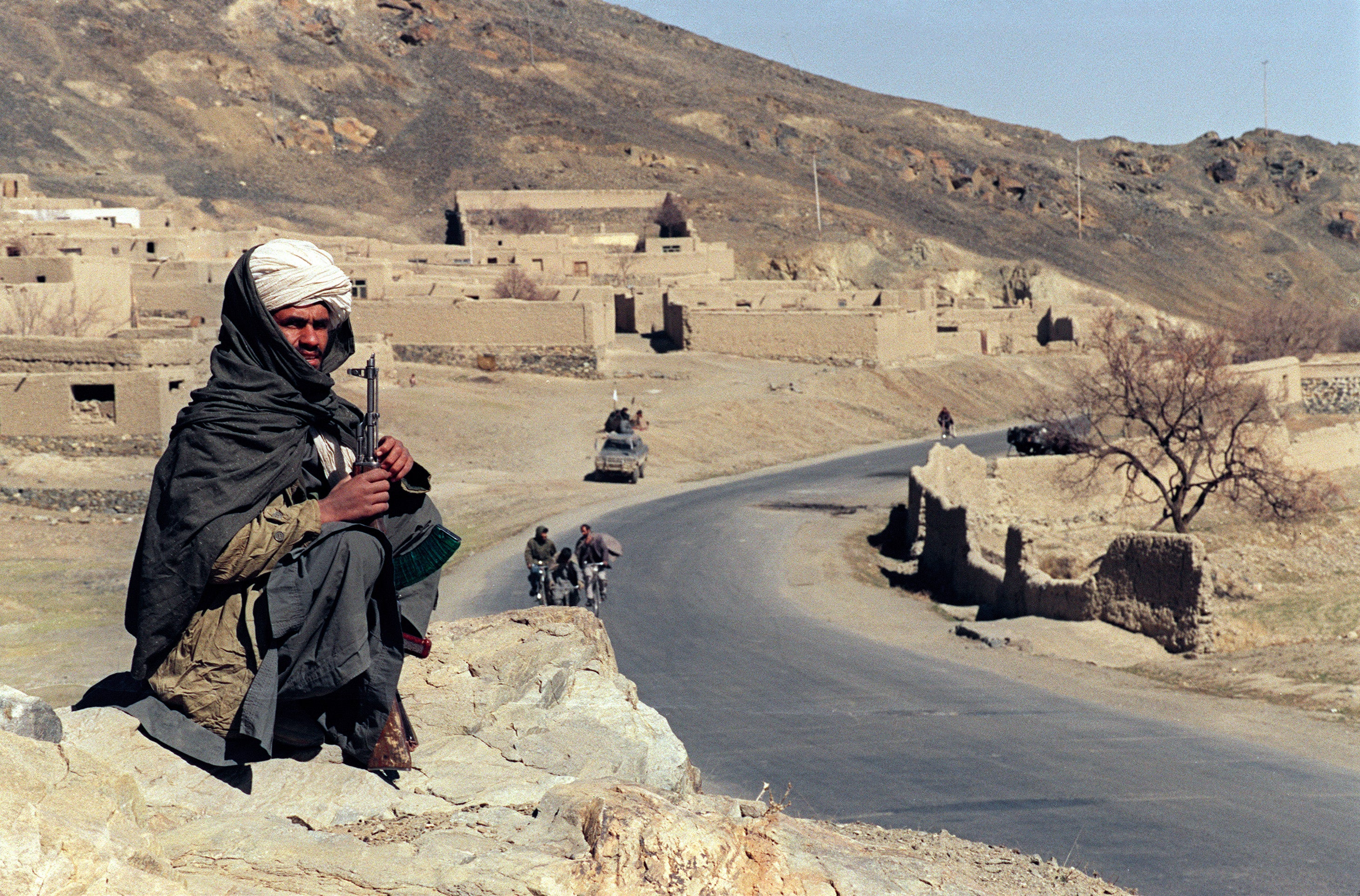 An Afghan fighter guards a road southeast of Kabul after Taliban troops enter the area with no resistance in February 1995