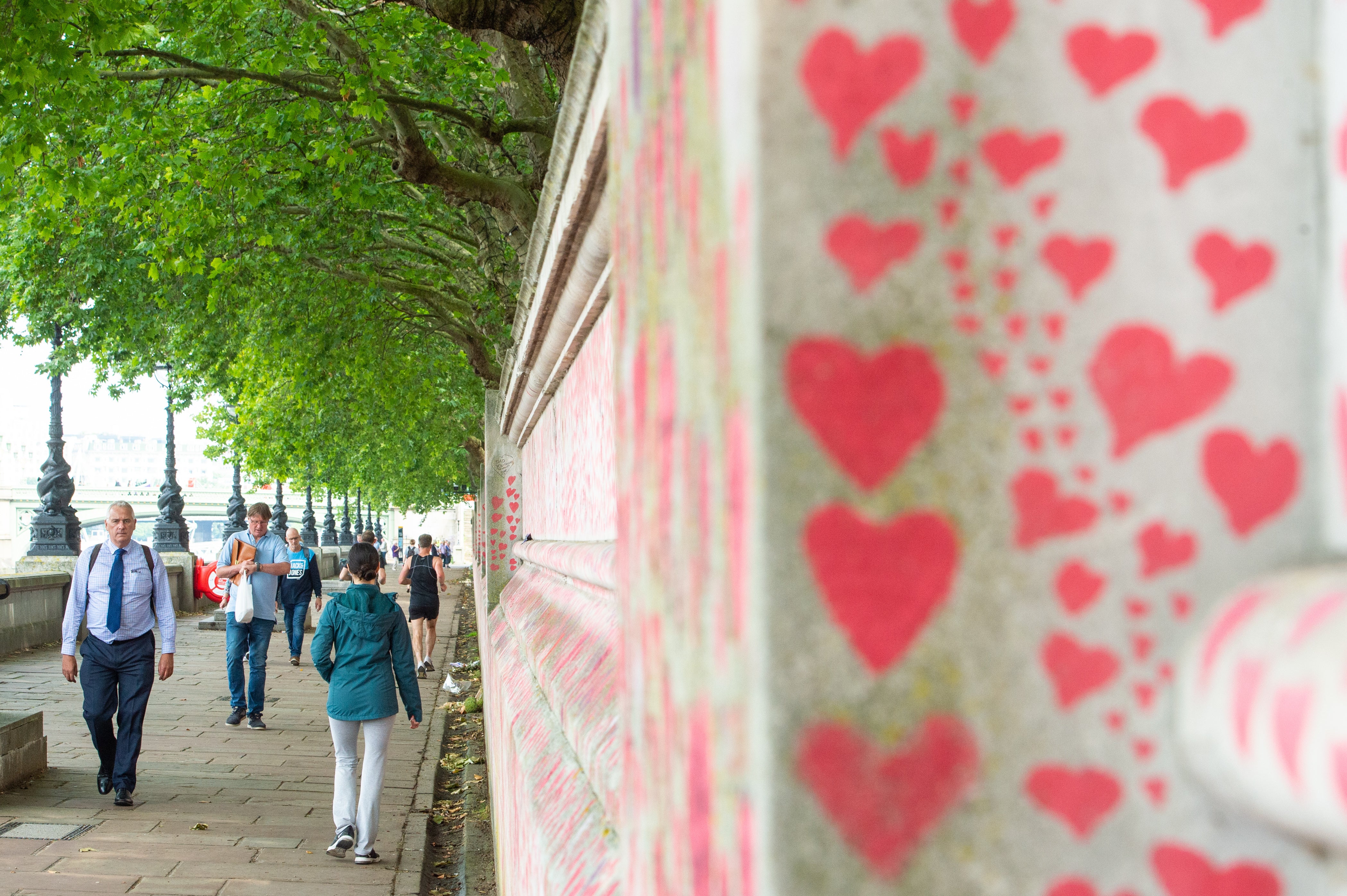 People walk past the Covid memorial wall in Westminster, London (Dominic Lipinski/PA)