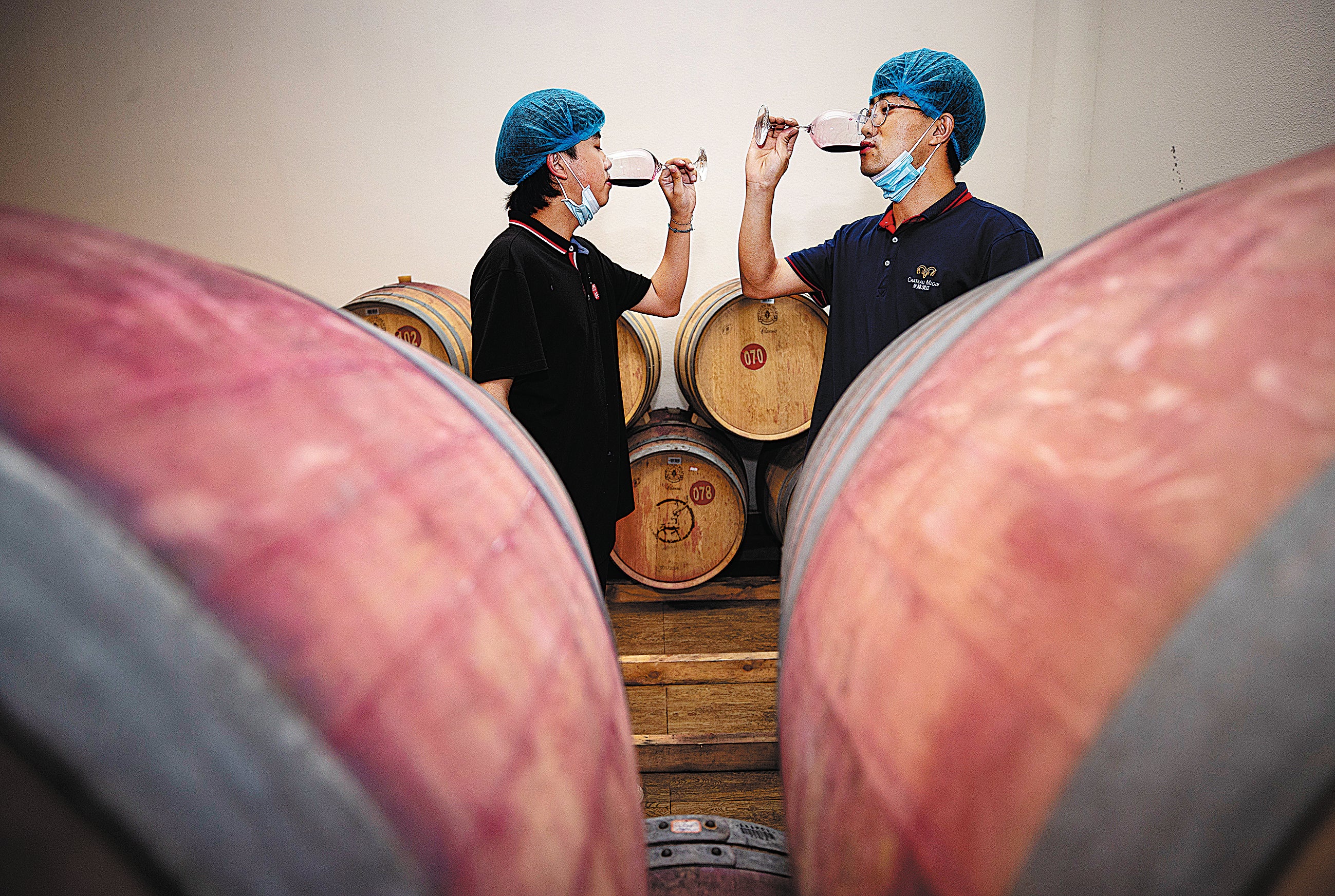 A staff member (right) and a student from the Food and Wine College of Ningxia University taste wine at a chateau located in the eastern foothills of Helan Mountains in the Ningxia Hui autonomous region in July