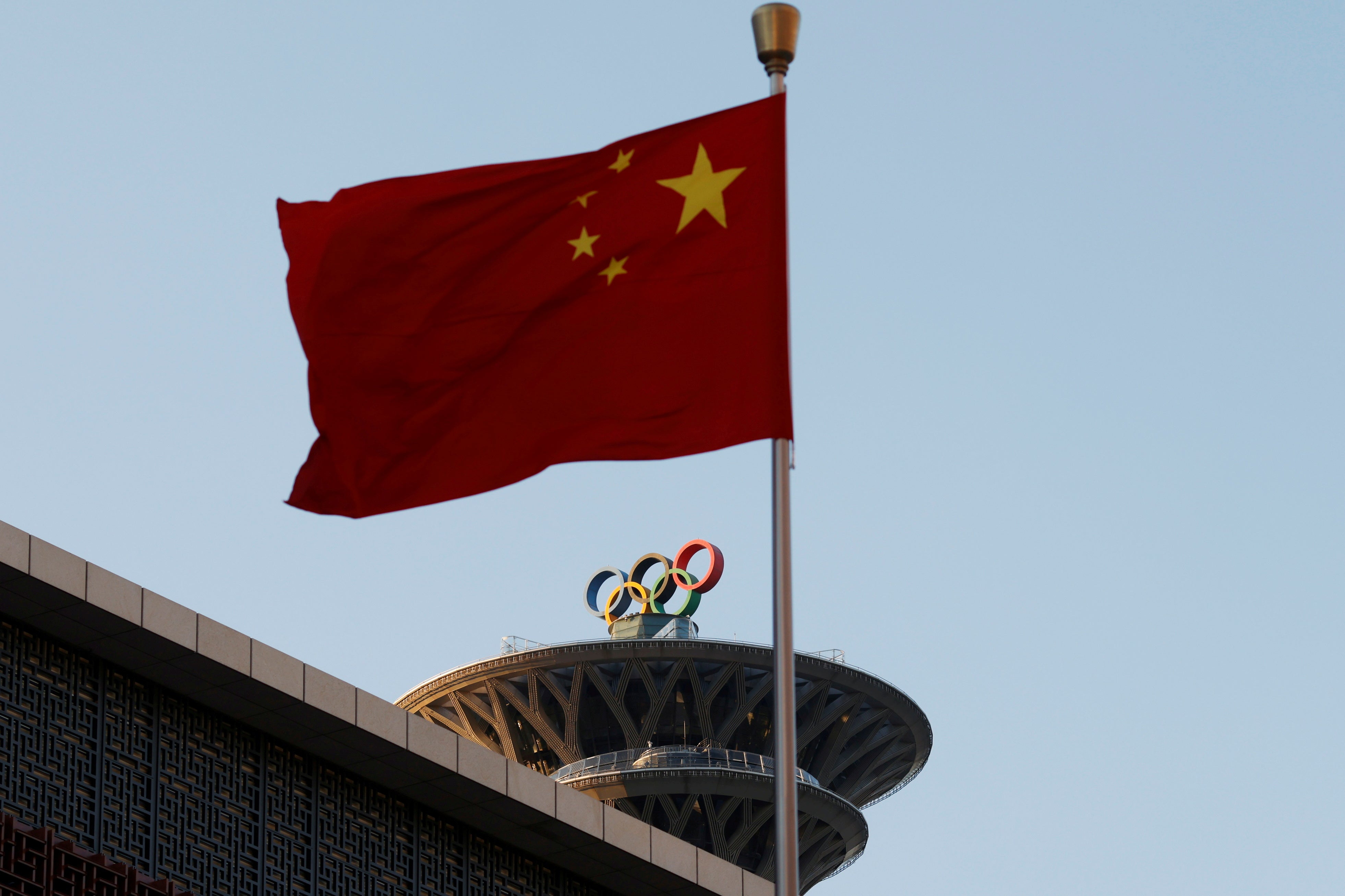 The Chinese flag flutters near the Olympic rings