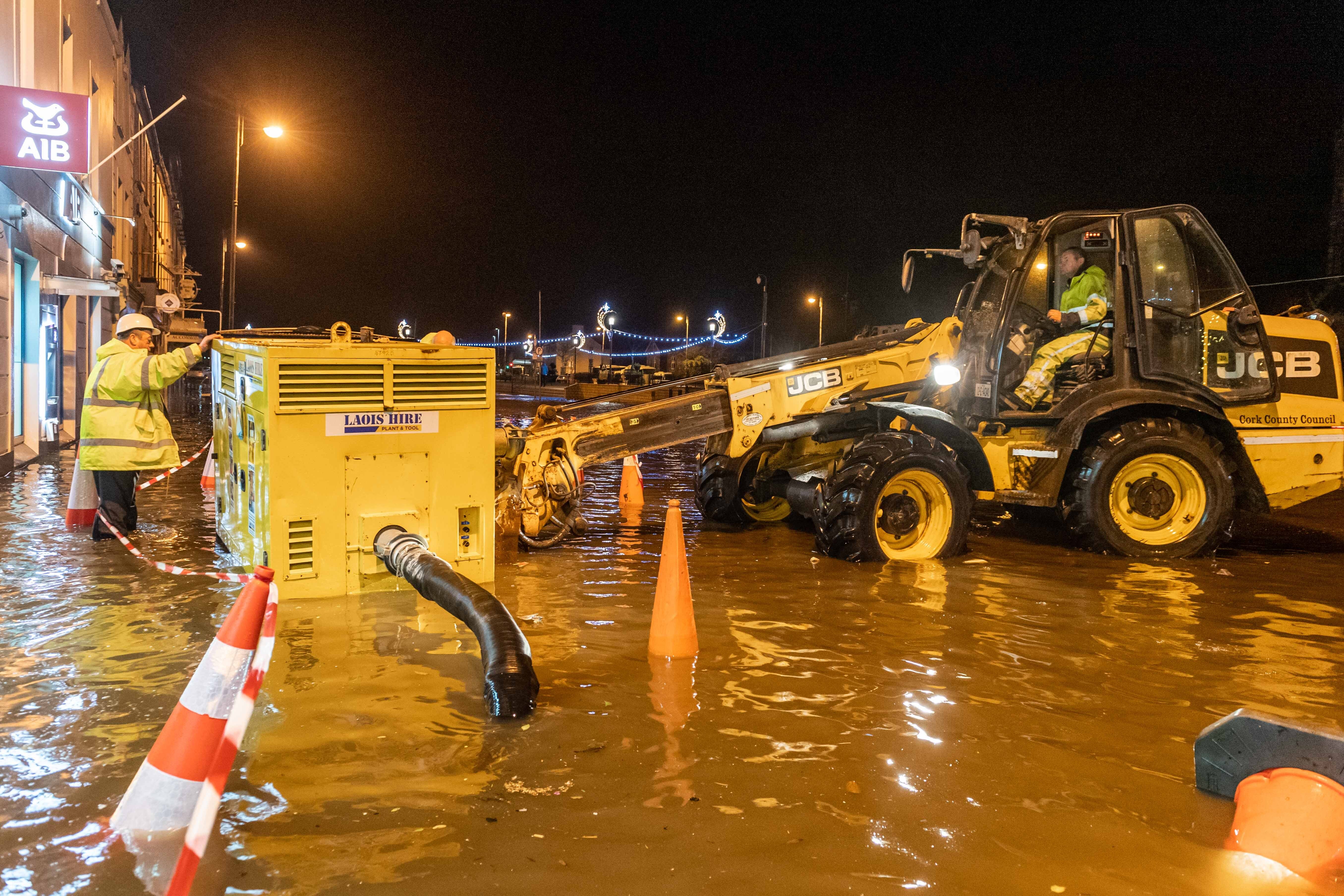 Workers manoeuvre a generator to help pump away floodwater in Bantry, County Cork, after Storm Barra hit the UK and Ireland with disruptive winds, heavy rain and snow (PA)