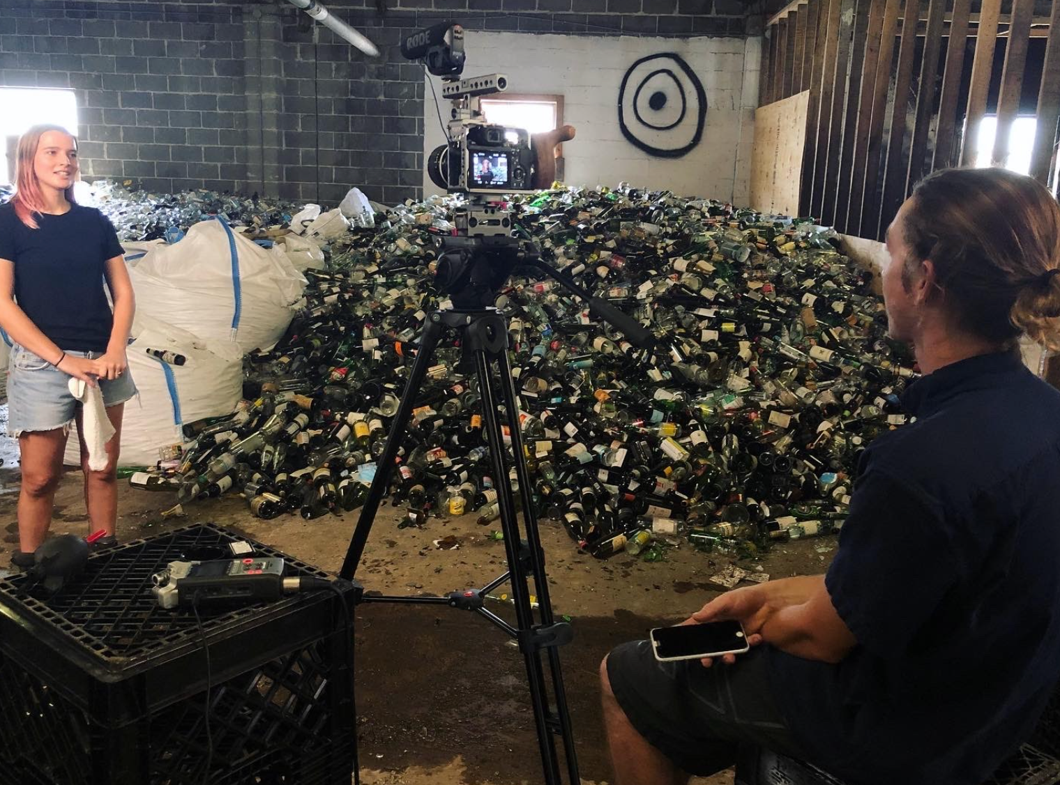 Franziska Trautmann, co-founder of Glass Half Full, in front of one of their mountains of glass for recycling