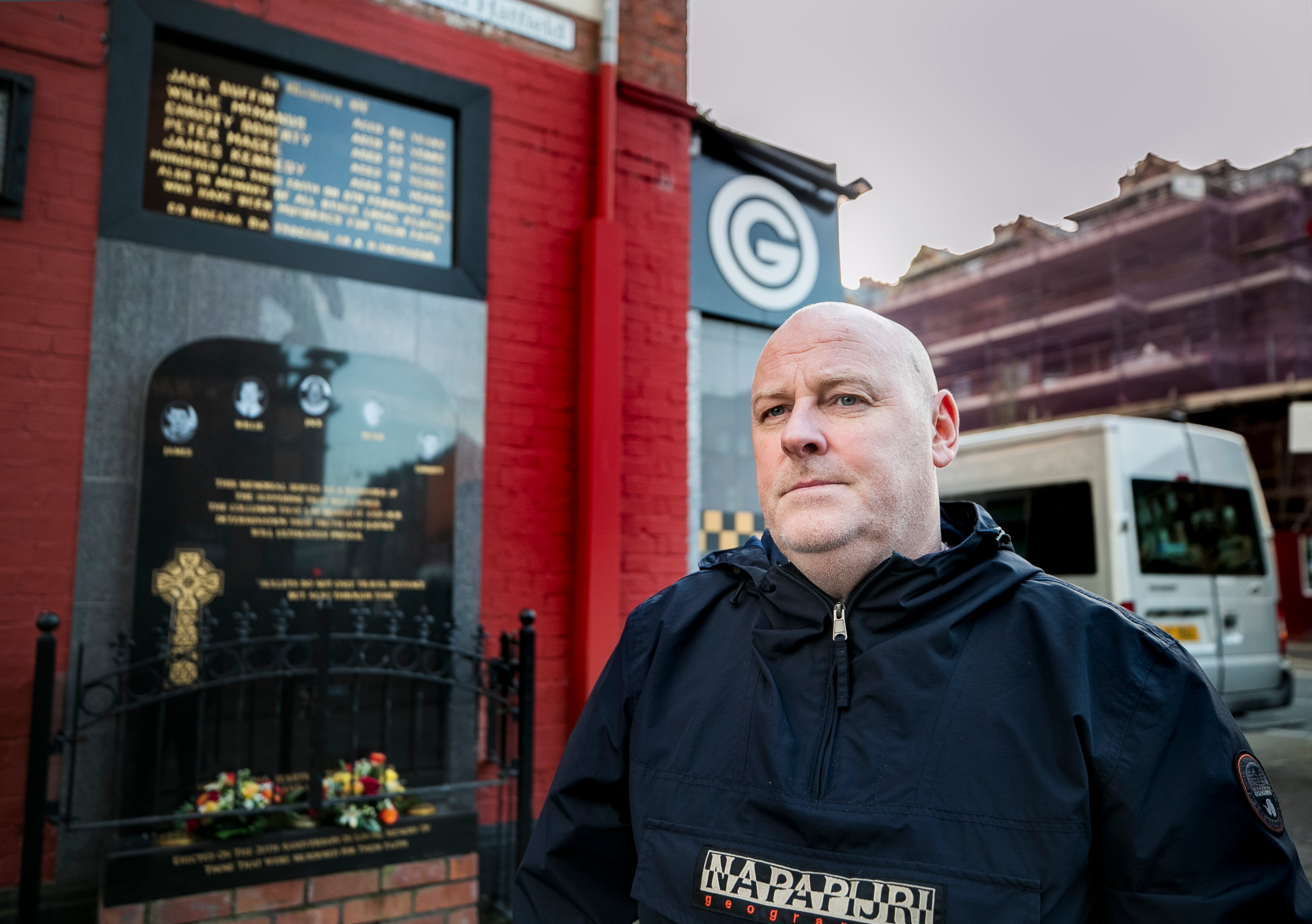 Mark Sykes stands at the memorial to those killed during the Sean Graham Bookmakers attack in 1992 (PA)