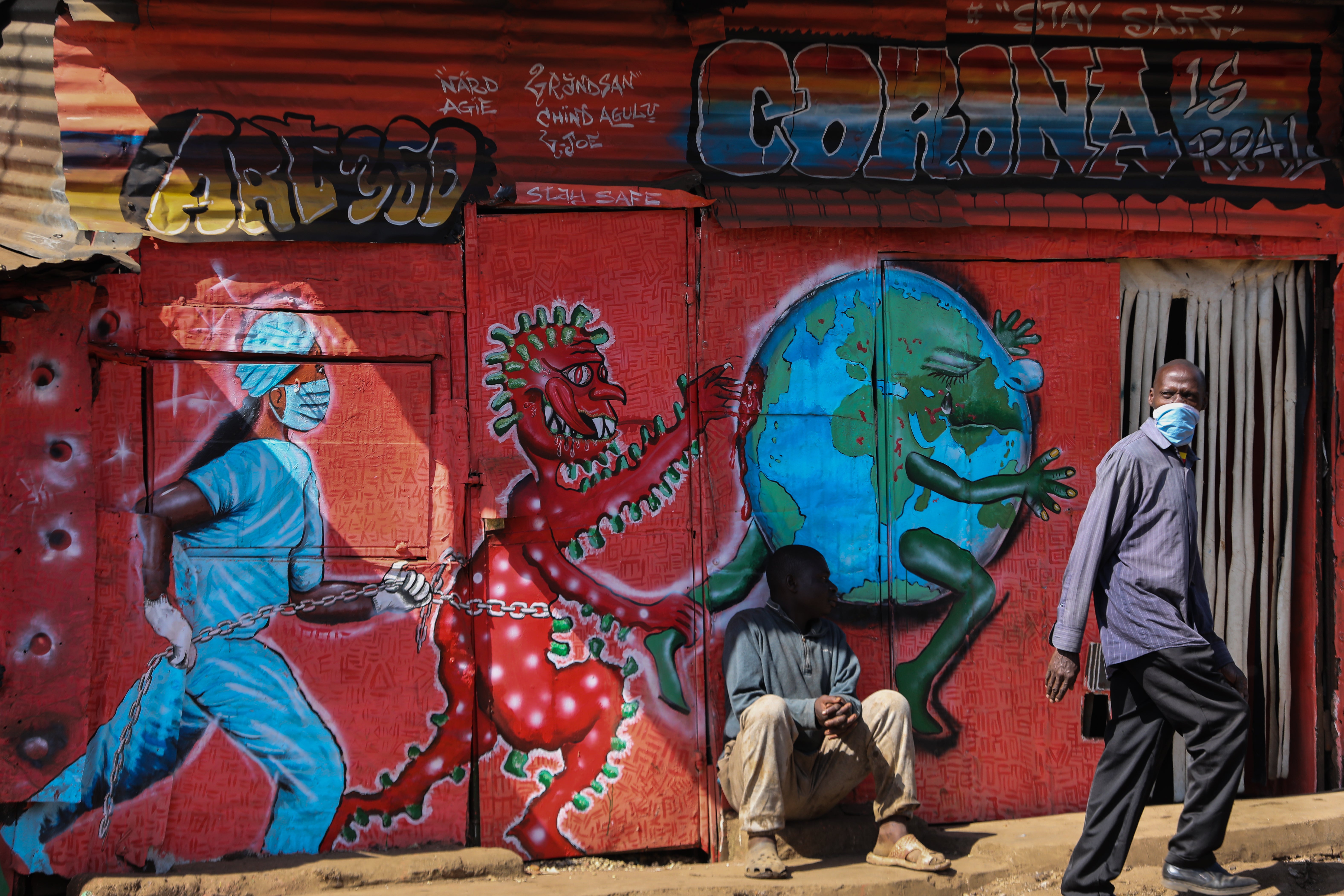 A man walks past a Covid mural in Kibera in Nairobi, Kenya, last year