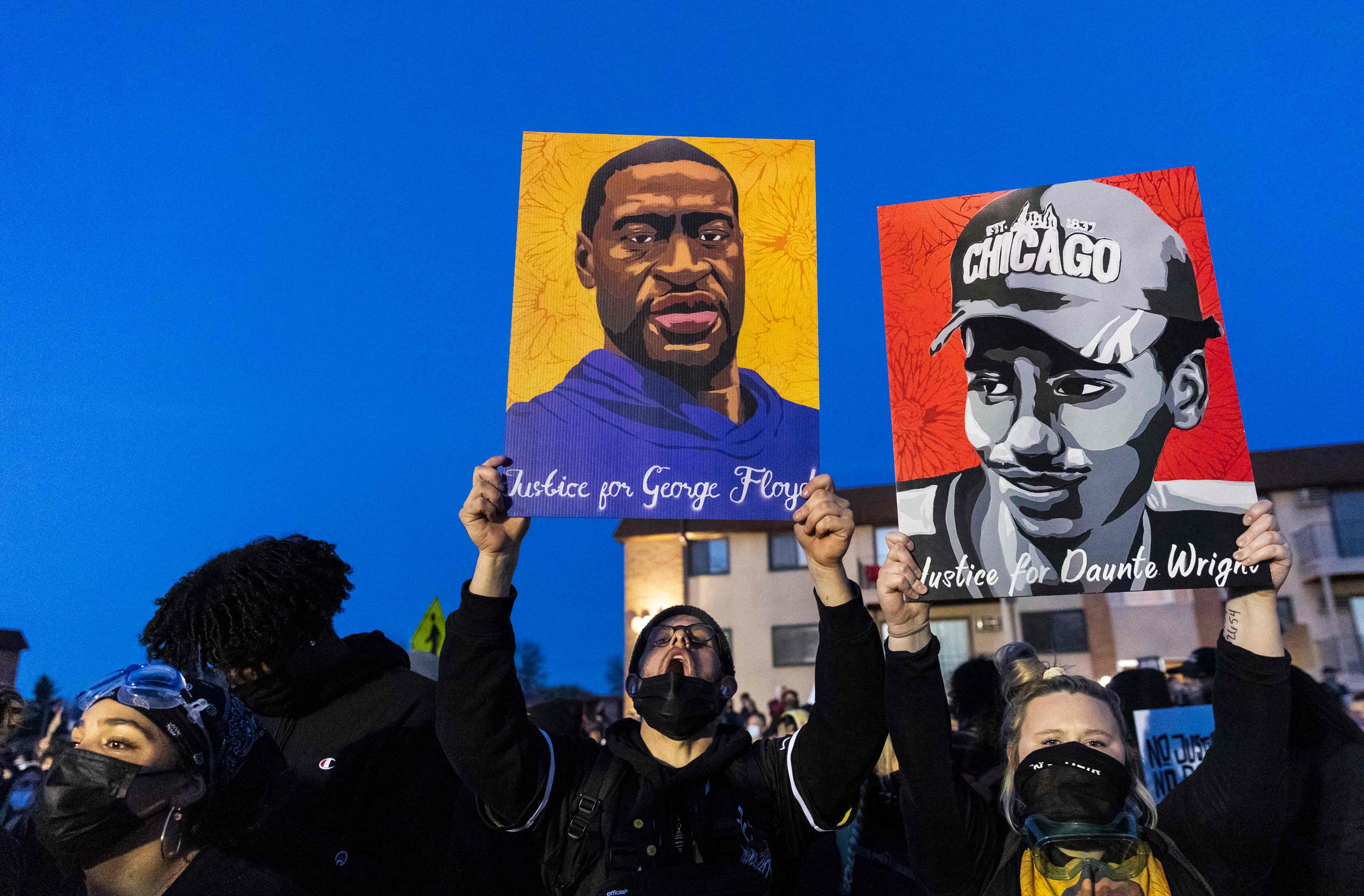 Protesters hold up sketches of George Floyd and Daunte Wright who were both killed by police officers in Minnesota