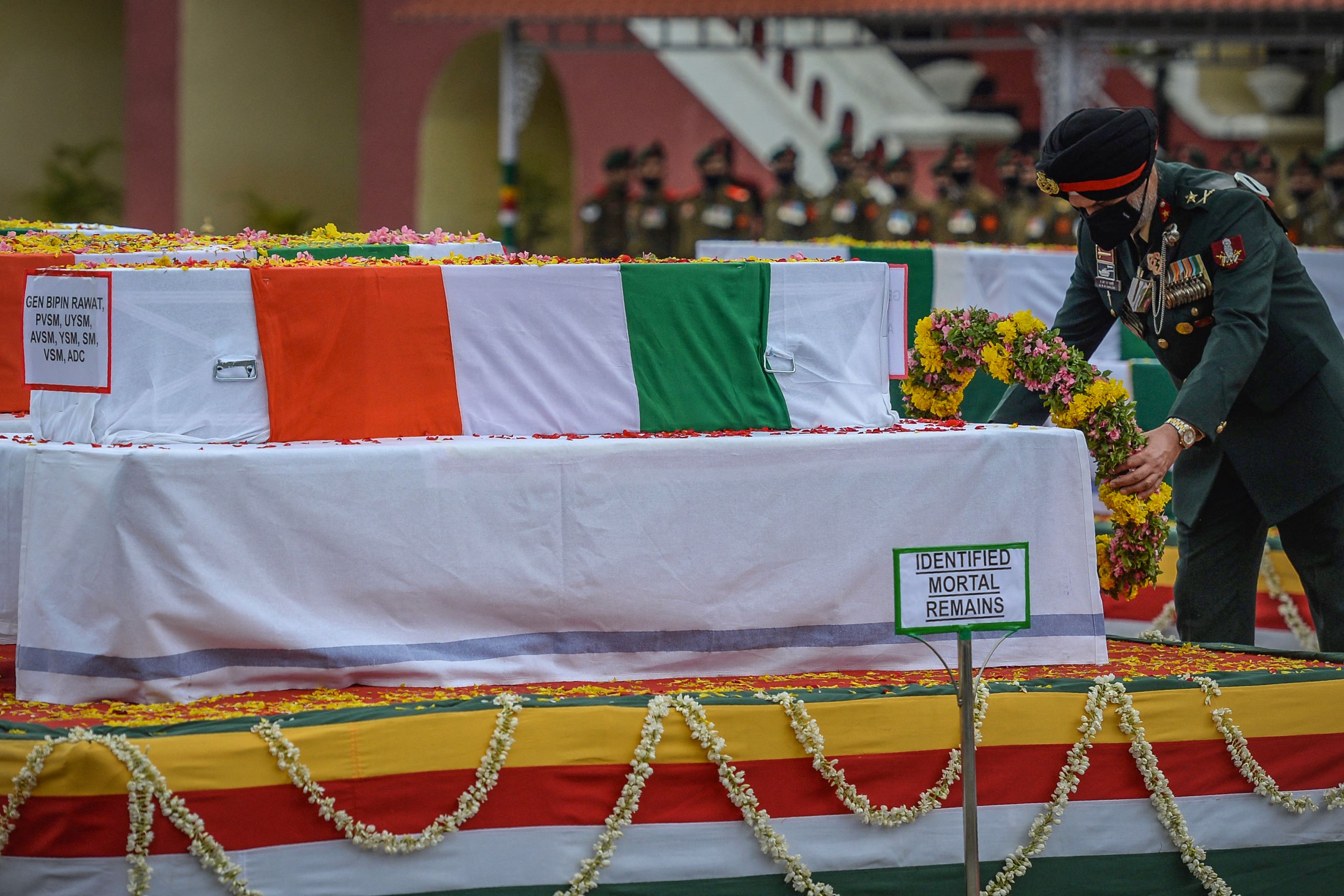 An Army officer pay respect near the coffin containing the mortal remains of Indian defence chief General Bipin Rawat who lost his life along with 13 others a day earlier in a helicopter crash