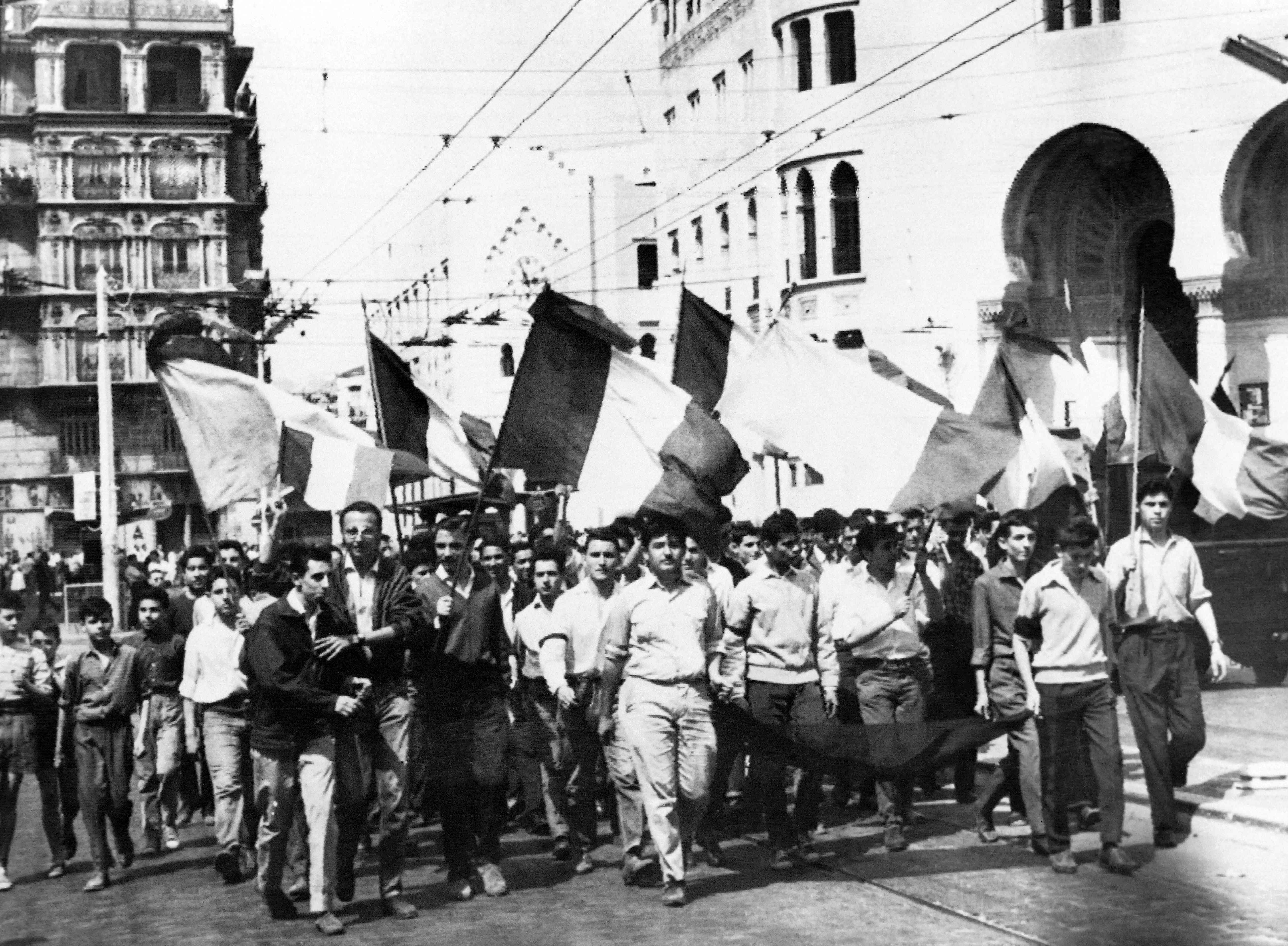 On May 13, 1958 young people waving French flags roam the streets of Algiers on their way to the Forum square and the government palace stormed by demonstrators, during the Algerian war.