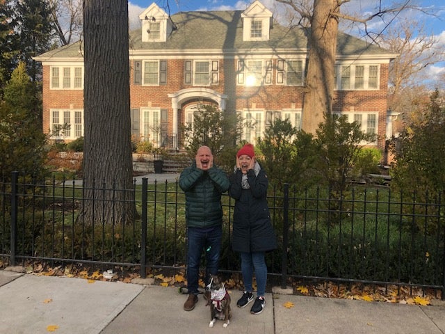 Jason and Chloe Barry, standing outside the Home Alone house in Winnetka, recreate a famous scene from the film; they’ve made a visit to the location an annual holiday tradition