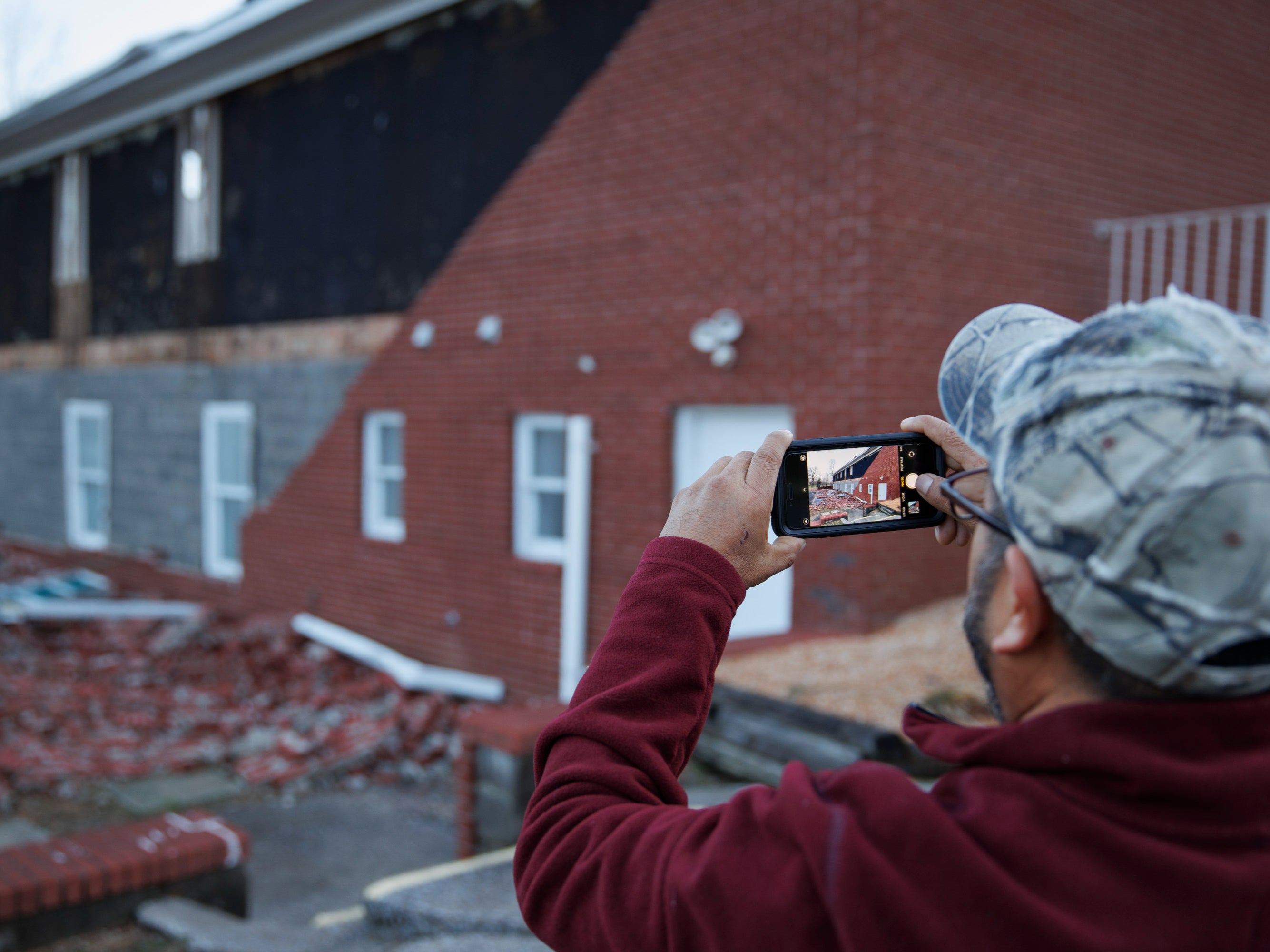 Miguel Macias surveys the damage to Emmanuel Baptist Church where he came for shelter last night during the tornado on December 11, 2021 in Mayfield, Kentucky