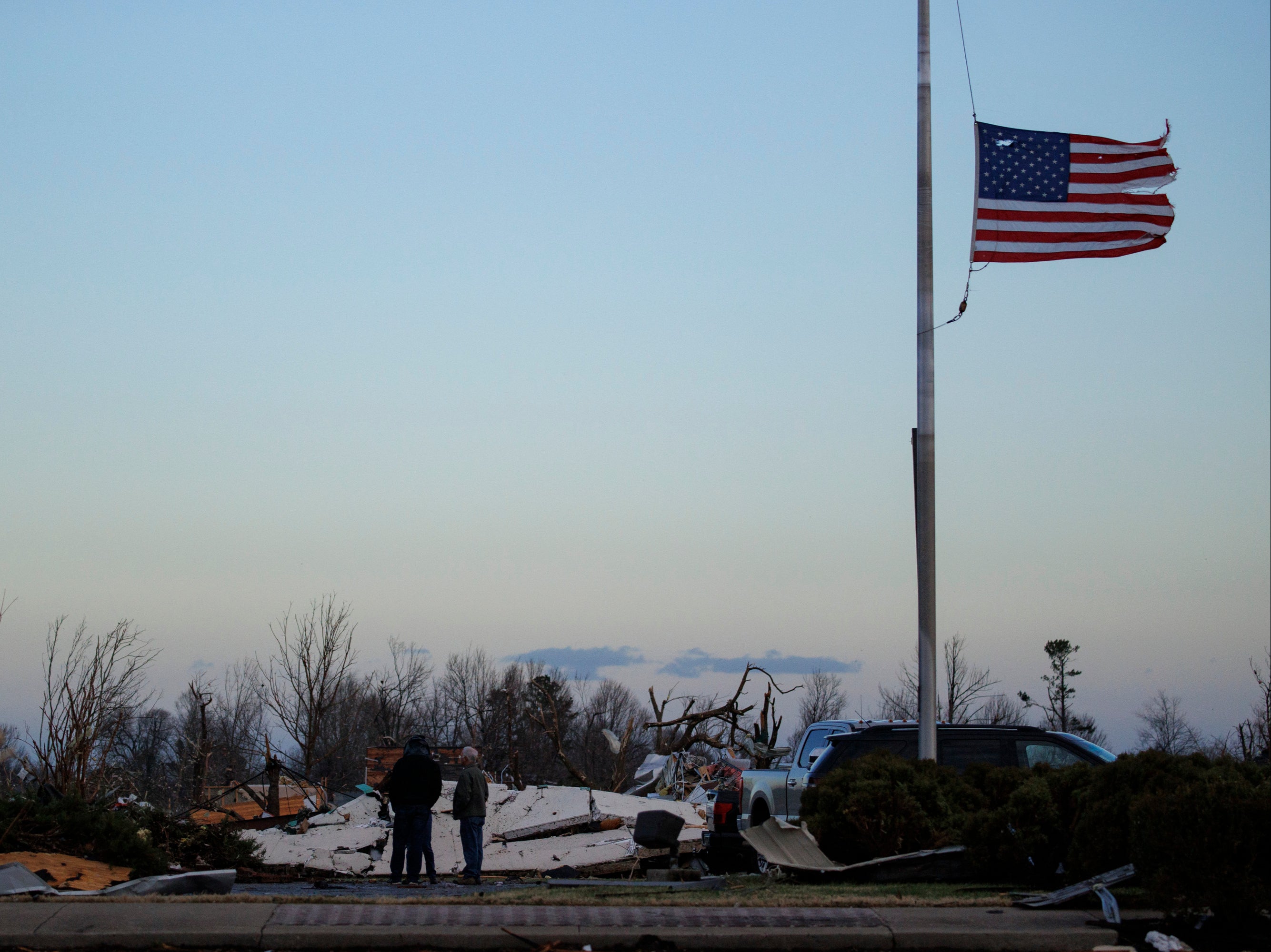 People survey tornado damage of the downtown area on December 11, 2021 in Mayfield, Kentucky